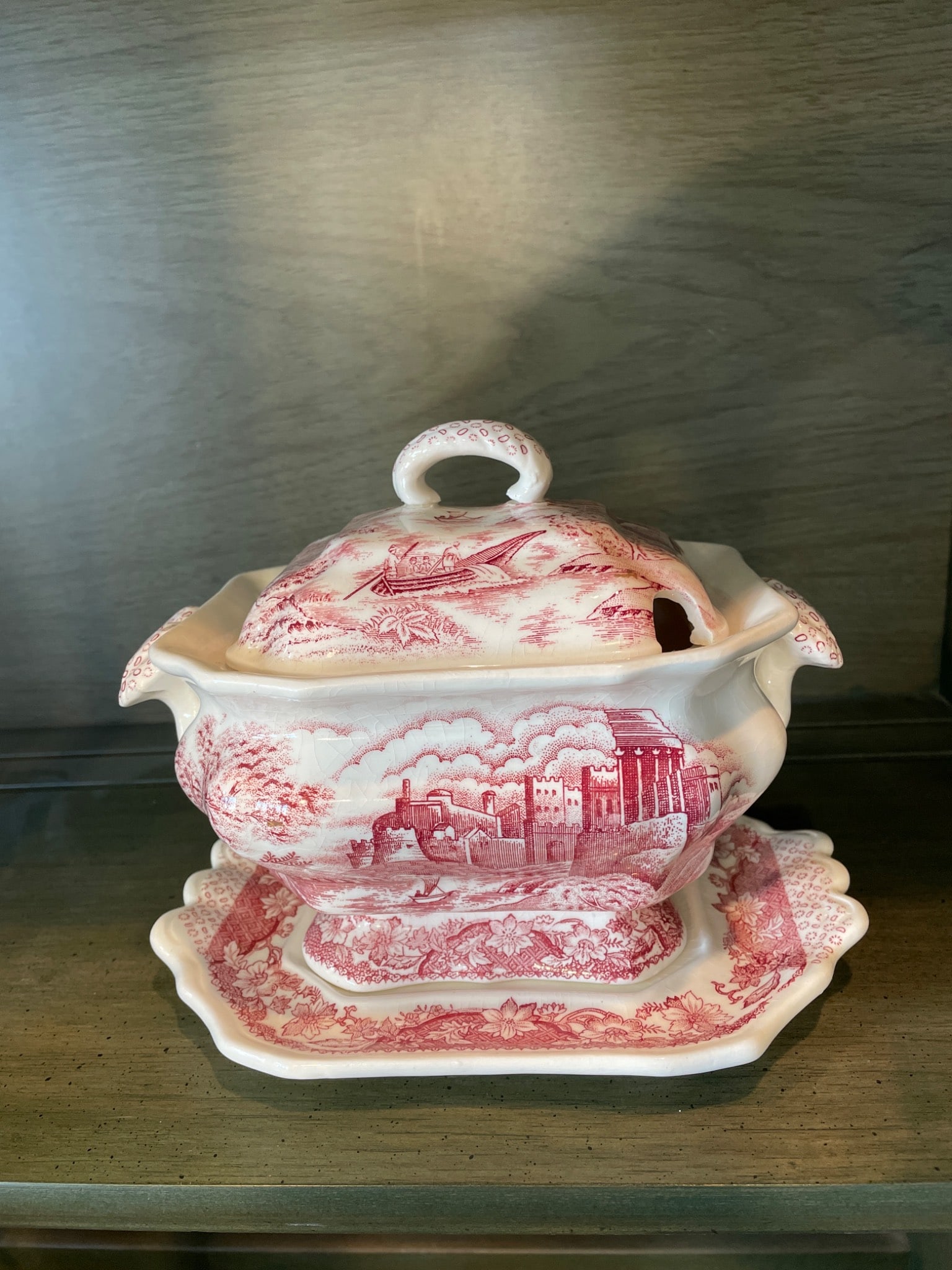 Red Transferware Tureen with Underplate and Lid, Partial Marks Visible: A red transferware tureen featuring pastoral and architectural motifs. Includes matching underplate and lid. The tureen measures approximately X inches in height. Partial marks are visible on the