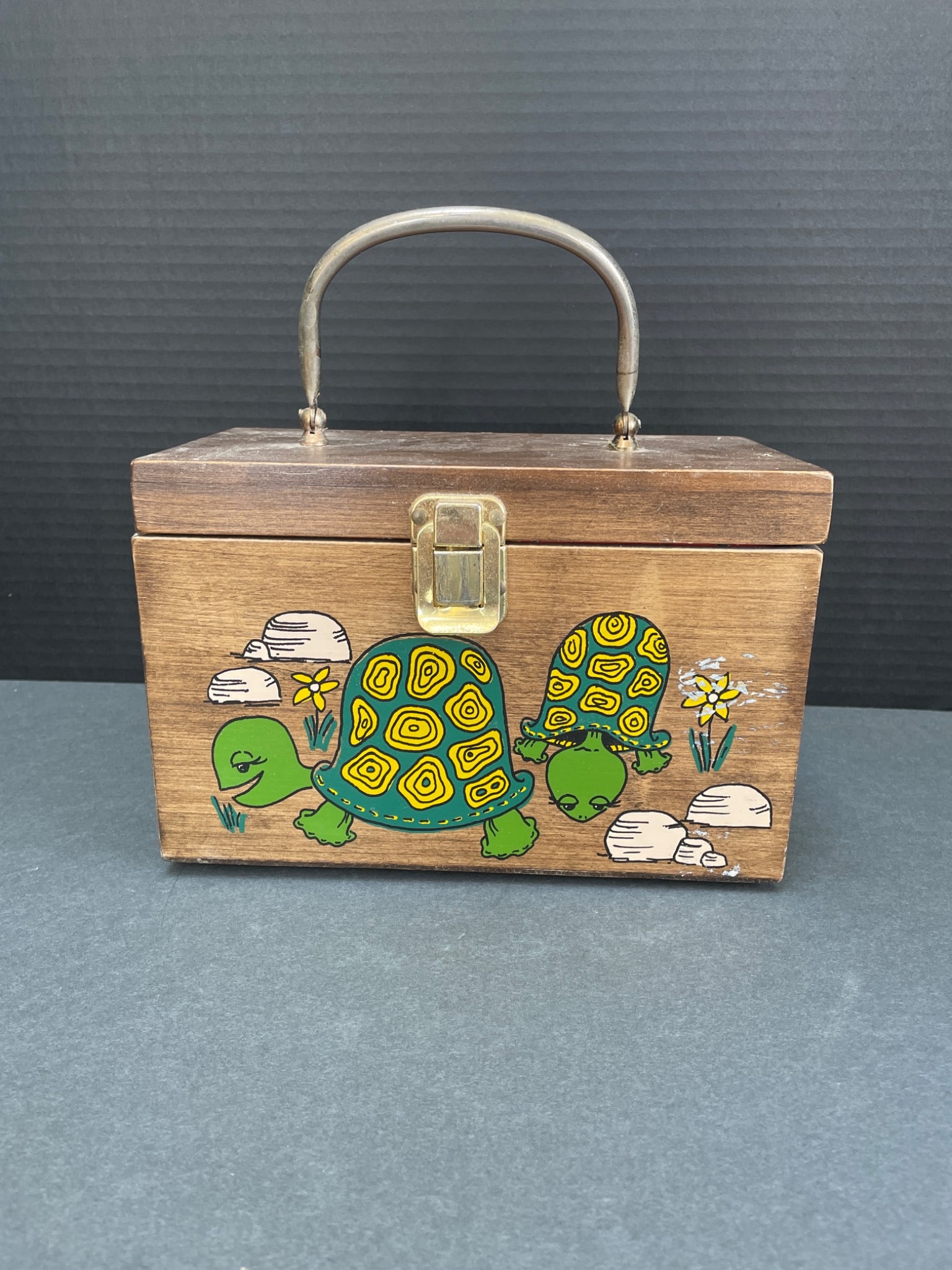Wooden Box with Hand-Painted Turtles and Red Fabric Lining: This is a wooden box with a metal handle, hand-painted designs of turtles on all four sides, and brass hardware. The interior is lined with red fabric featuring a floral pattern, and the lid includes