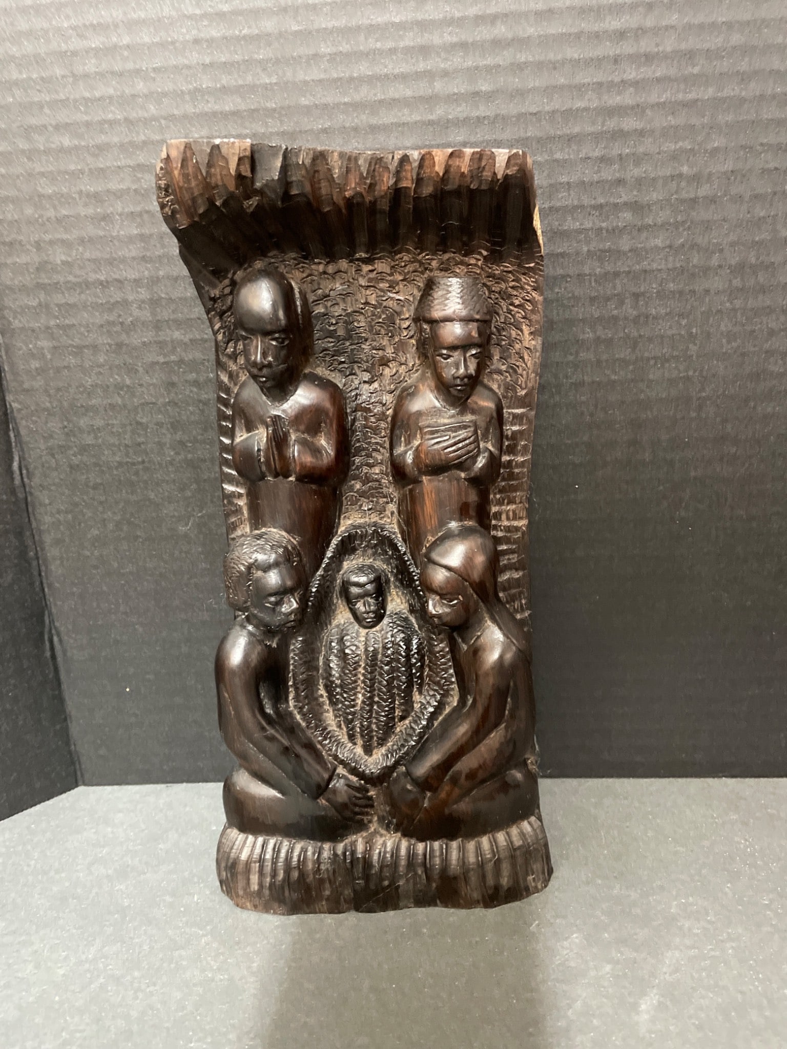 Hand-Carved Wooden Figurine Depicting Group Scene, 12 Inches Tall: This is a hand-carved wooden figurine depicting a scene with five figures, possibly cultural or religious in theme. The carving is vertically oriented, measuring approximately 12 inches tall, as