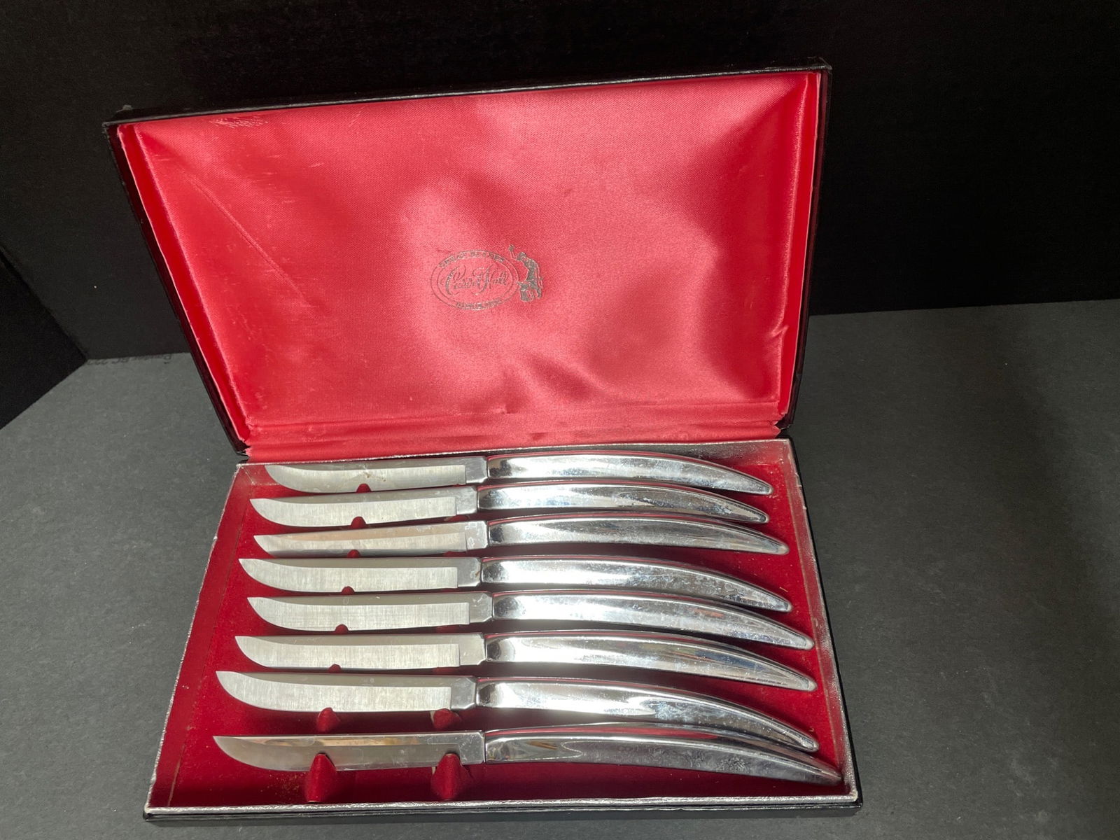 Carvel Hall Stainless Steel Steak Knife Set in Red Case: 8 Carvel Hall stainless steel steak knives housed in a red satin-lined presentation case. The knives feature polished blades and ergonomic handles, marked 'Carvel Hall' on the blade. Includes