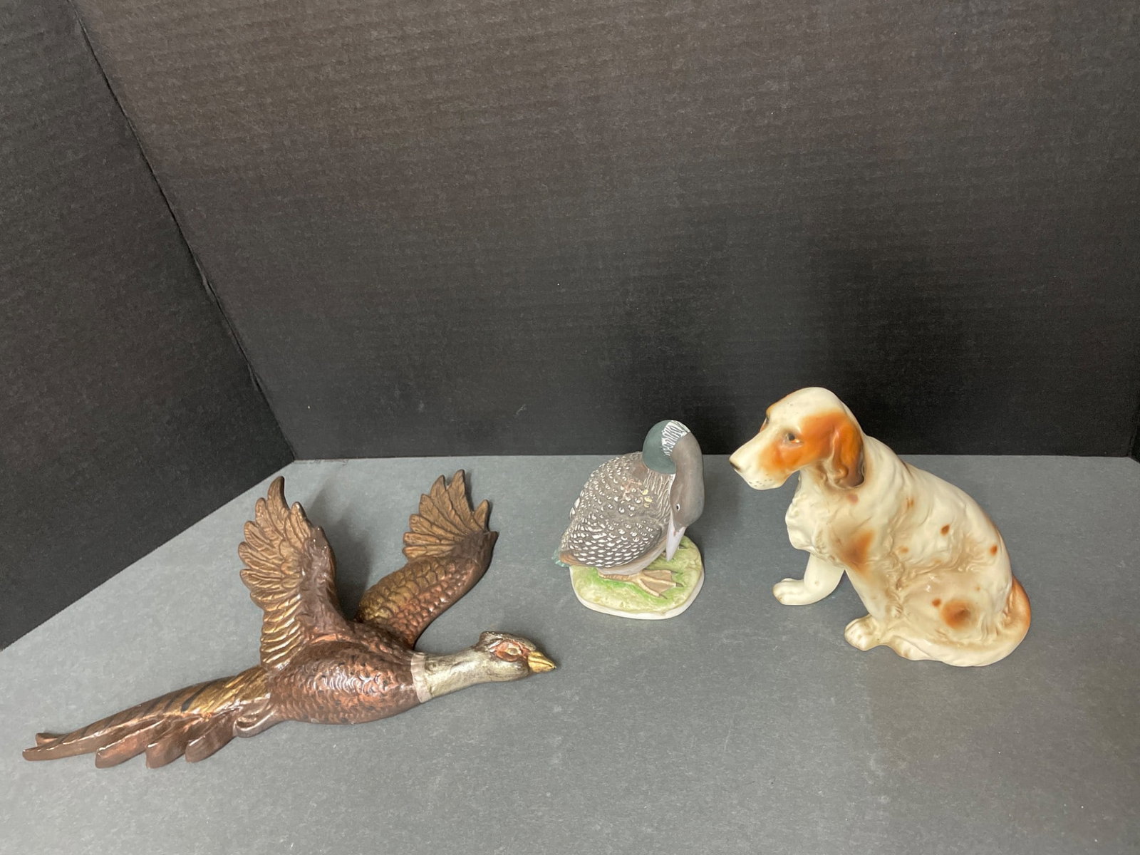 Three Ceramic Figurines: Dog, Pheasant, and Goose with Maker Marks: This lot includes three ceramic figurines: a dog marked 'Made in Japan' with the number S837U, a pheasant figurine with an unmarked base, and a goose figurine marked with 'Loom' and 'KW 321' on the bo