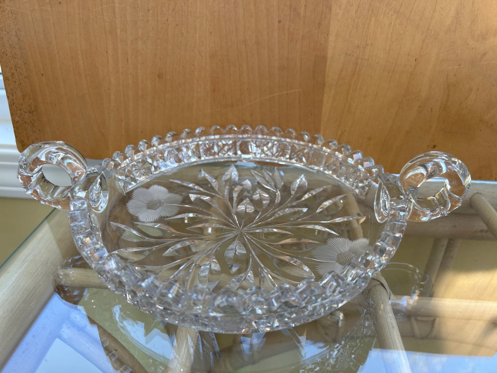 Clear Glass Dish With Handles and Etched Floral Motif, Approx. 10 Inches Wide: This is a clear glass dish featuring etched floral and leaf patterns on the base and handles for easy carrying. The dish measures approximately 10 inches wide, including the handles, per the scale