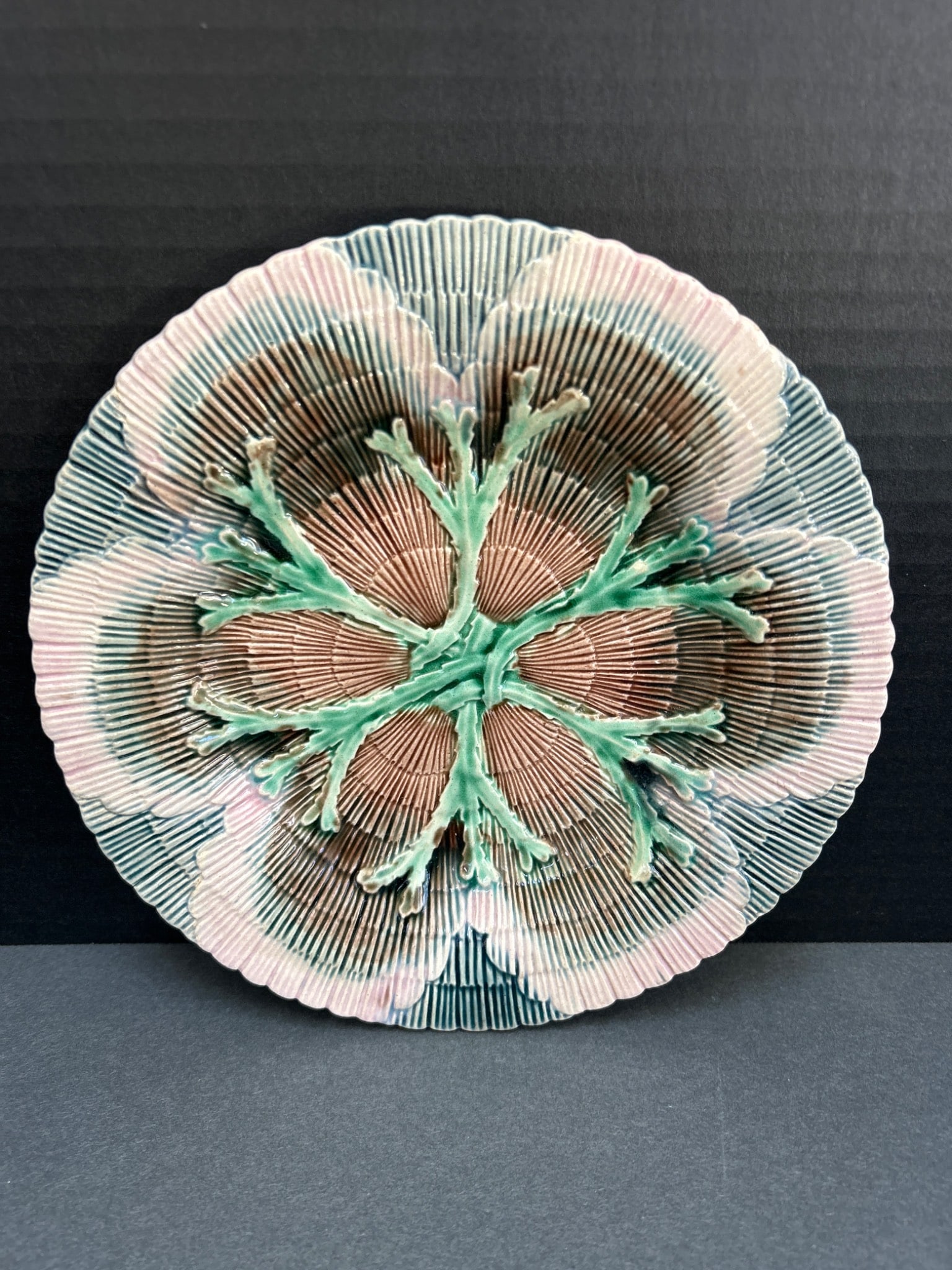 Etruscan Majolica Plate With Floral Relief Motif: Etruscan majolica plate featuring a detailed floral relief design with green, pink, and brown accents. The plate measures approximately 8 inches in diameter. The underside is stamped with 'Etruscan