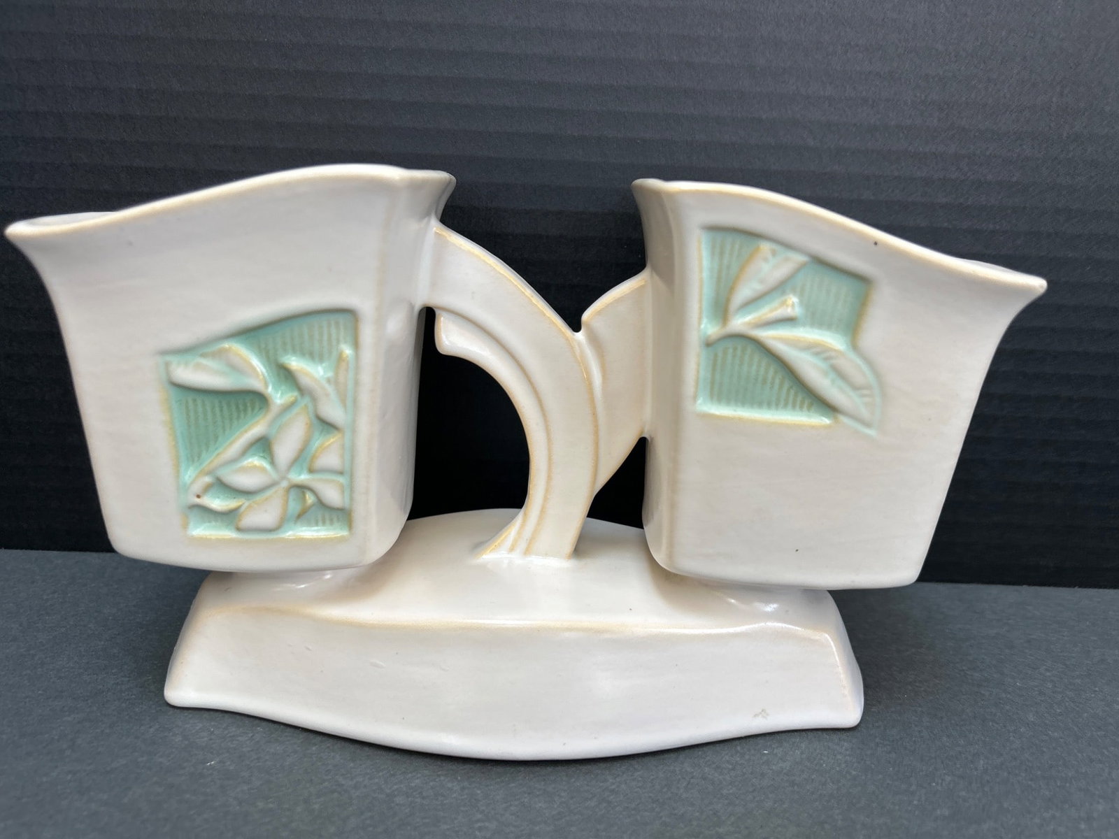 Roseville Pottery Model 757-9 Double Vase with Floral Motif: This item is a double vase produced by Roseville Pottery. It is marked 'Roseville U.S.A. 757-9' on the underside, indicating its model number and size. The vase features a floral motif with light