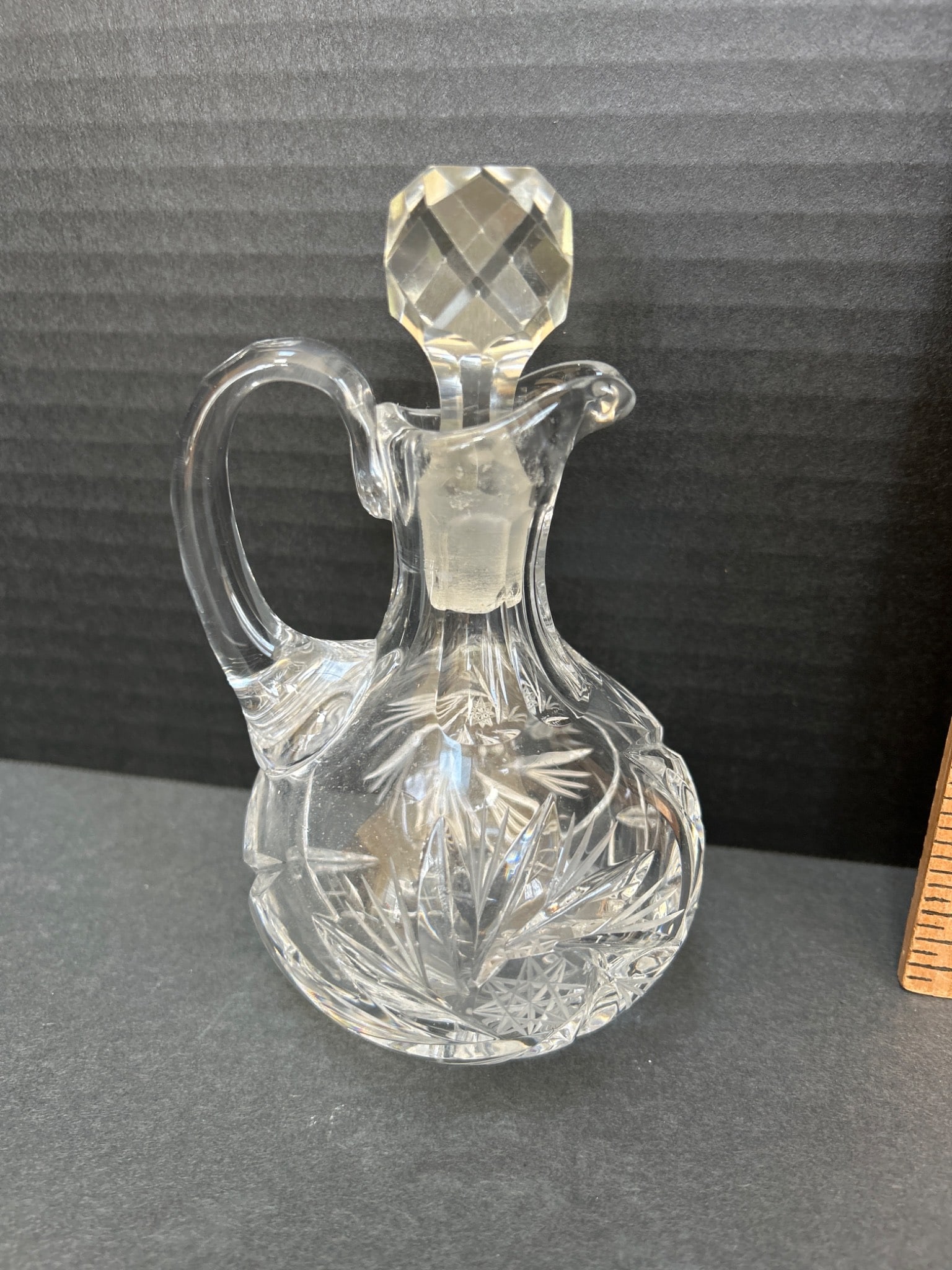 Cut Glass Cruet with Stopper and Etched Design, 7 Inches Tall: This lot includes a cut glass cruet with stopper, standing approximately 7 inches tall (including stopper). Features an etched floral or foliage design on the body and a faceted stopper. No visible