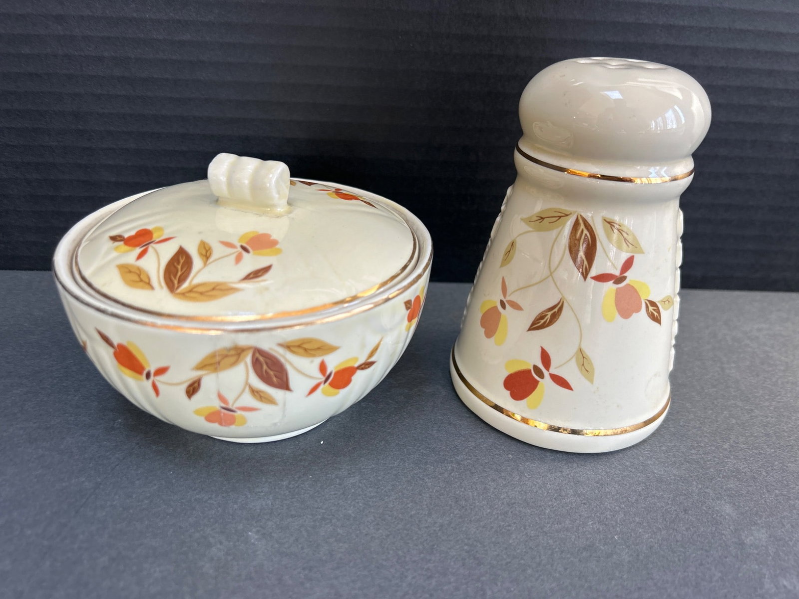 Hall's Superior Quality Kitchenware Cheese Shaker and Lidded Bowl with Floral Design: This lot includes a Hall's Superior Quality Kitchenware cheese shaker and a matching lidded bowl, both featuring a floral pattern with gold accents. The cheese shaker has "CHEESE" embossed on the