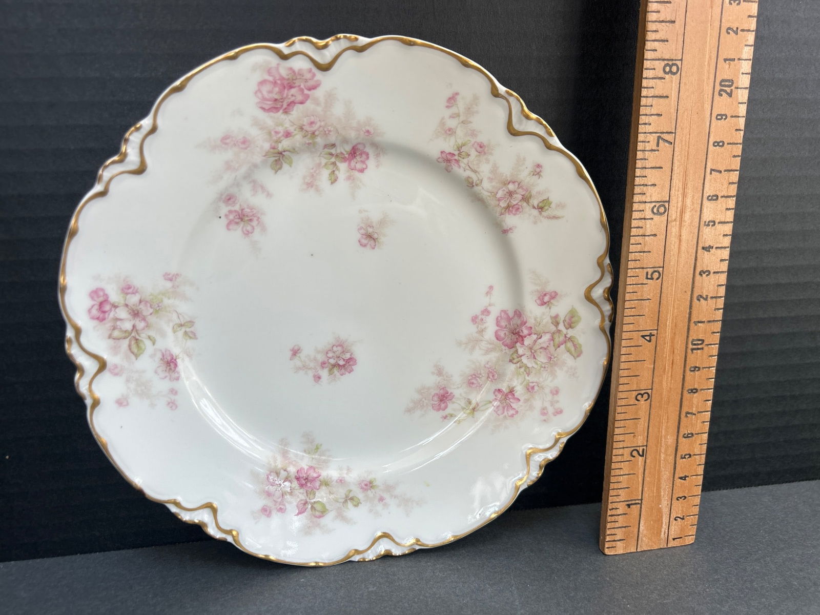 Haviland & Co. Limoges 7.5-Inch Decorative Plate with Floral Design: This is a 7.5-inch decorative porcelain plate by Haviland & Co., crafted in Limoges, France. The plate features a scalloped edge, a pink floral pattern, and gold accents. The backstamp identifies it