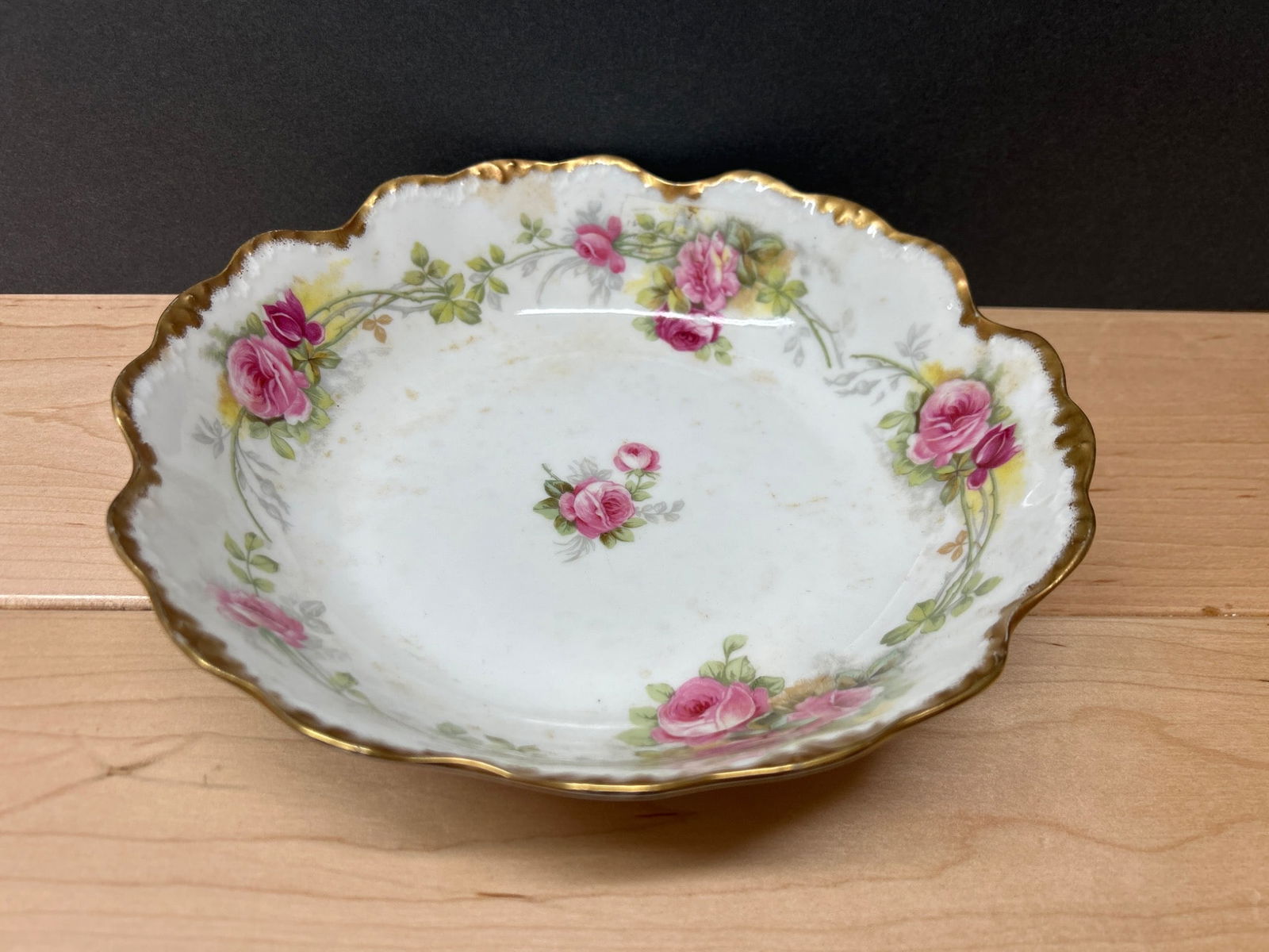 Elite Works Limoges Porcelain Bowl With Pink Rose Pattern and Gold Trim: A scalloped porcelain bowl manufactured by Elite Works, Limoges, France. The bowl features a pink rose pattern with green foliage, complemented by gold trim along the edge. Marked 'Elite L France' in