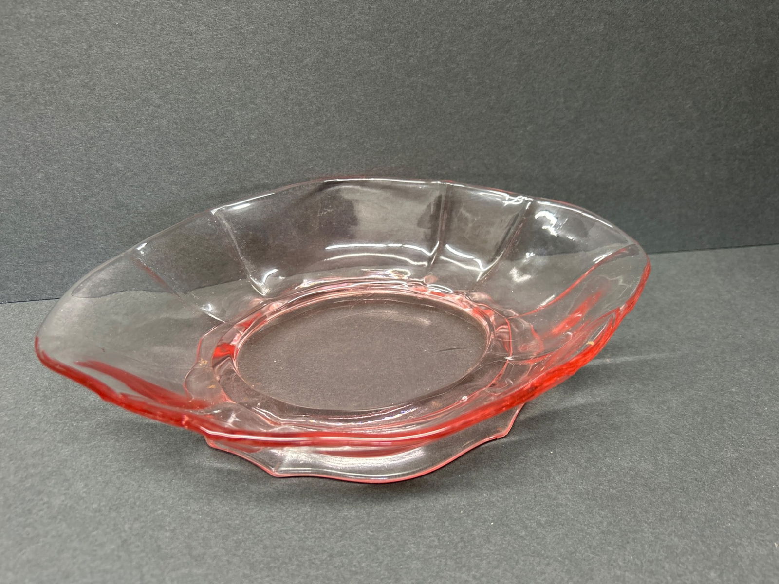 Red Transparent Glass Bowl with Fluted Rim and Base Support: This is a red transparent glass bowl featuring a fluted rim and a raised base support. It measures approximately 7 inches in diameter, as shown in the images with a measuring tool. The design
