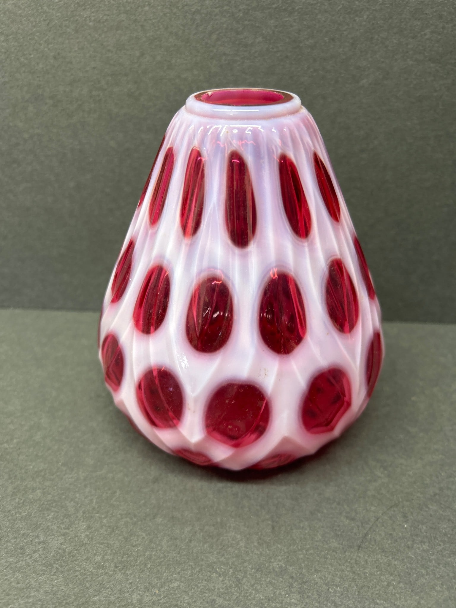 Opalescent Glass Vase with Red Thumbprint Design, Approximately 5 Inches High: This is an opalescent glass vase featuring a red thumbprint design throughout. The vase stands approximately 5 inches tall, as shown in the accompanying ruler measurements. It exhibits a swirl