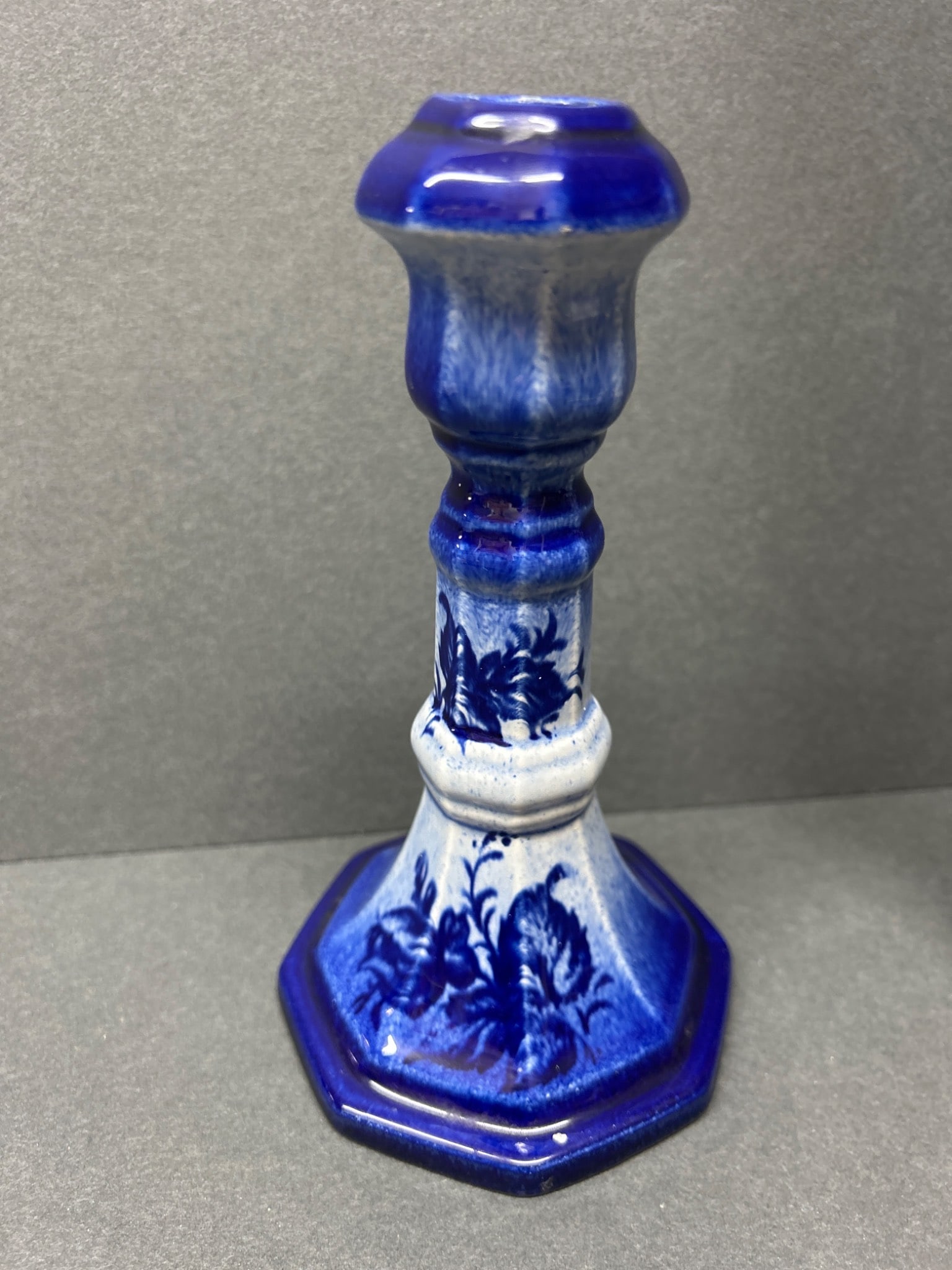 Blue Ceramic Candlestick With Octagonal Base and Floral Motif: This is a ceramic candlestick featuring a blue glaze with gradient effect and floral motifs. The piece has an octagonal base, a hollow design through the center, and stands approximately 6 inches tall