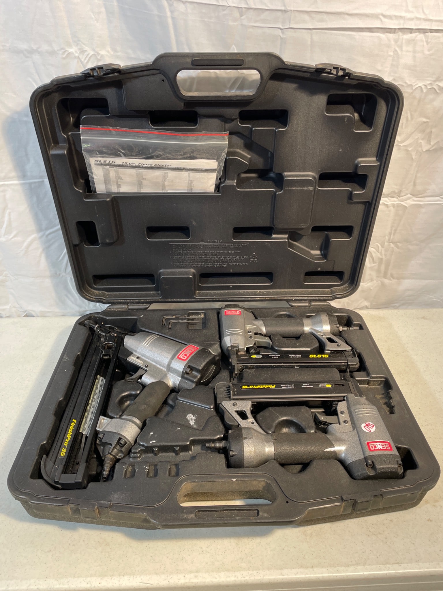 Senco Finish Nailers Set With Case and Accessories: This lot includes a Senco finish nailer set, comprising multiple nailers (models FinishPro 35, SLS15, and FinishPro 15) and accompanying accessories, all housed in the original manufacturer's carrying