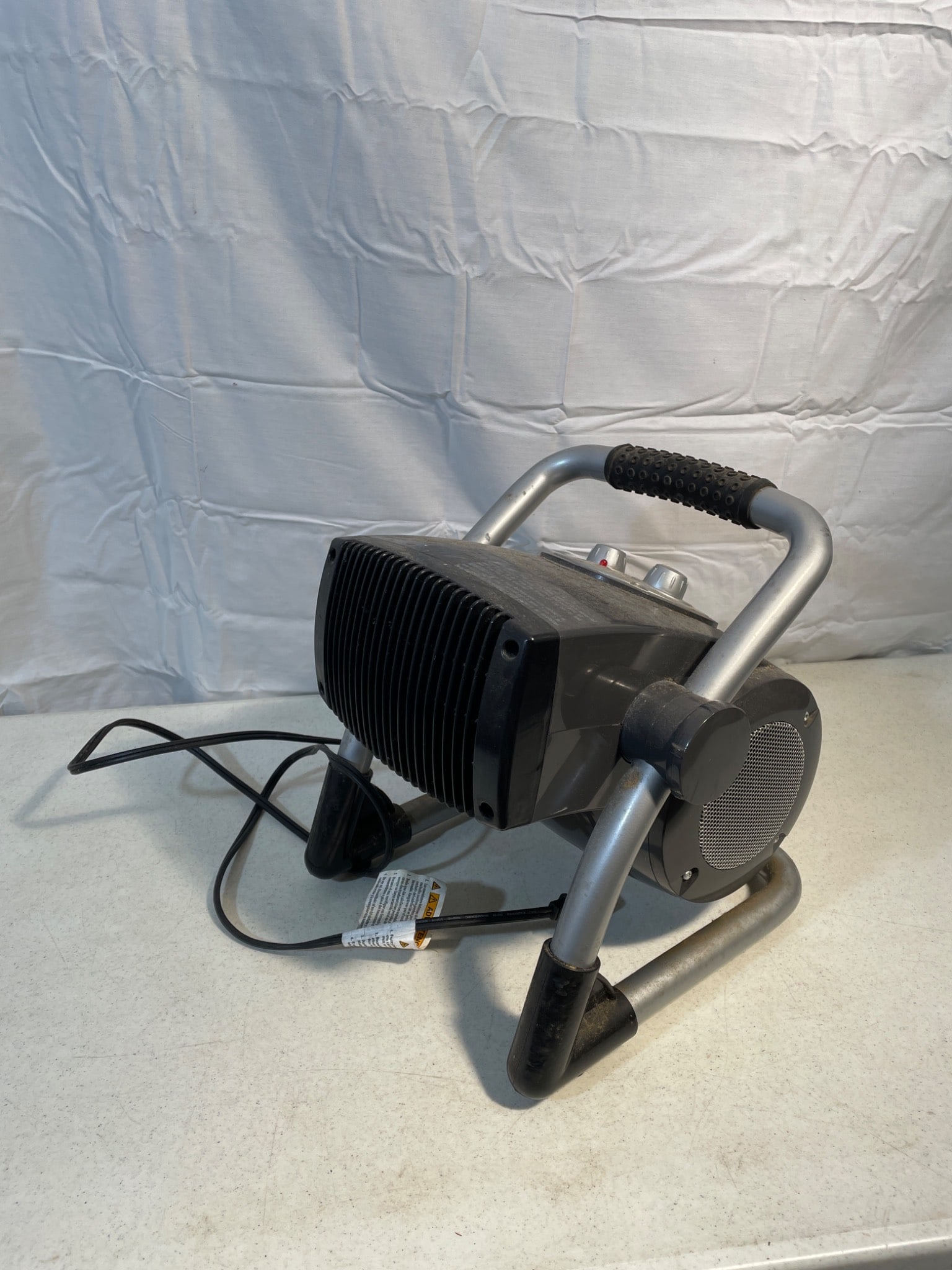 Lasko Utility Heater Model 675919 with Adjustable Thermostat: This is a Lasko utility heater, model 675919, featuring an adjustable thermostat and a durable metal frame. It is ideal for personal or workspace heating. The heater includes a power cord and user