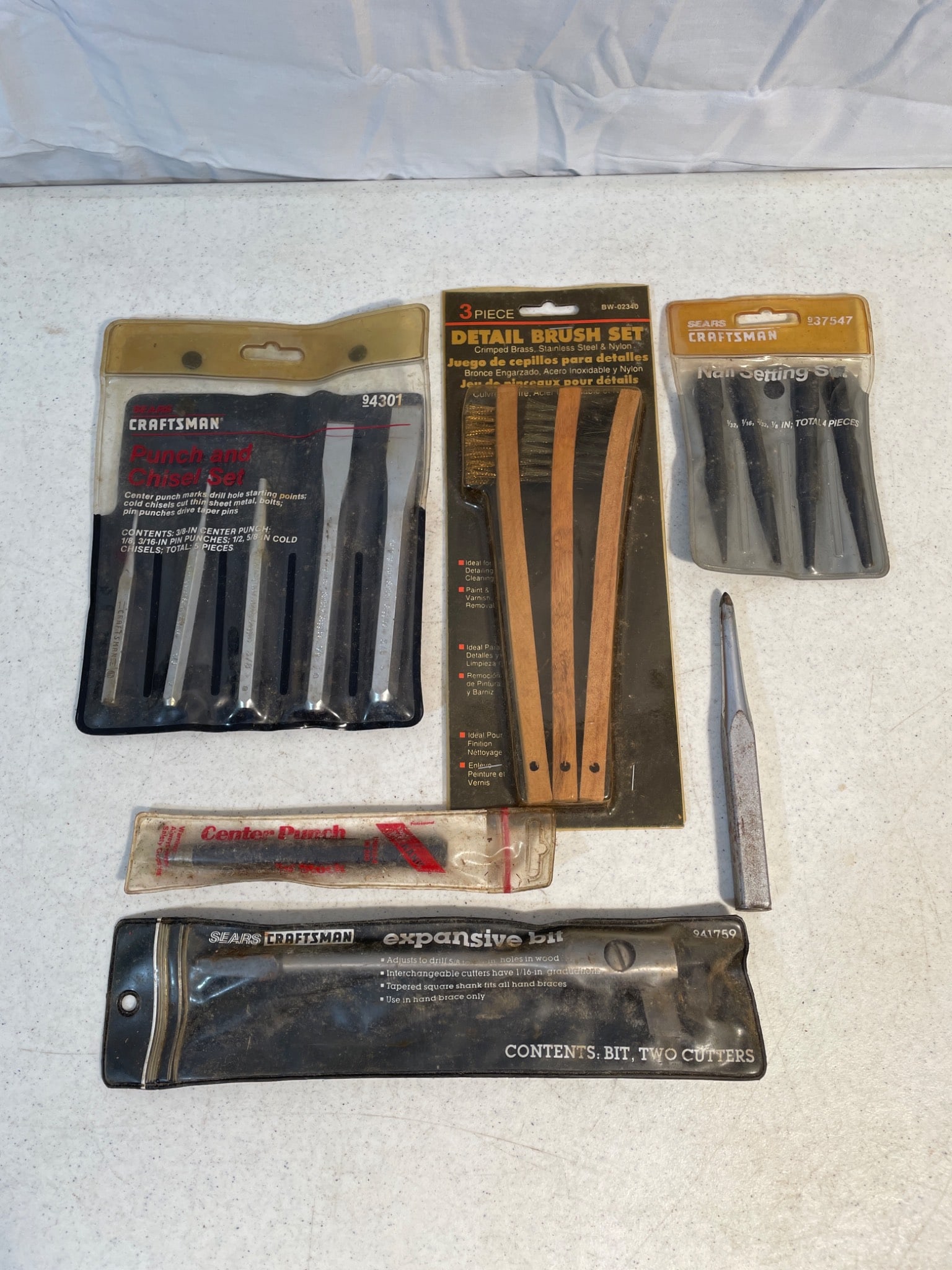 Craftsman and Miscellaneous Hand Tools and Accessories: This lot includes a collection of tools and accessories, consisting of Craftsman brand punches and chisels, a detail brush set, and various other tool accessories. The items are contained in their