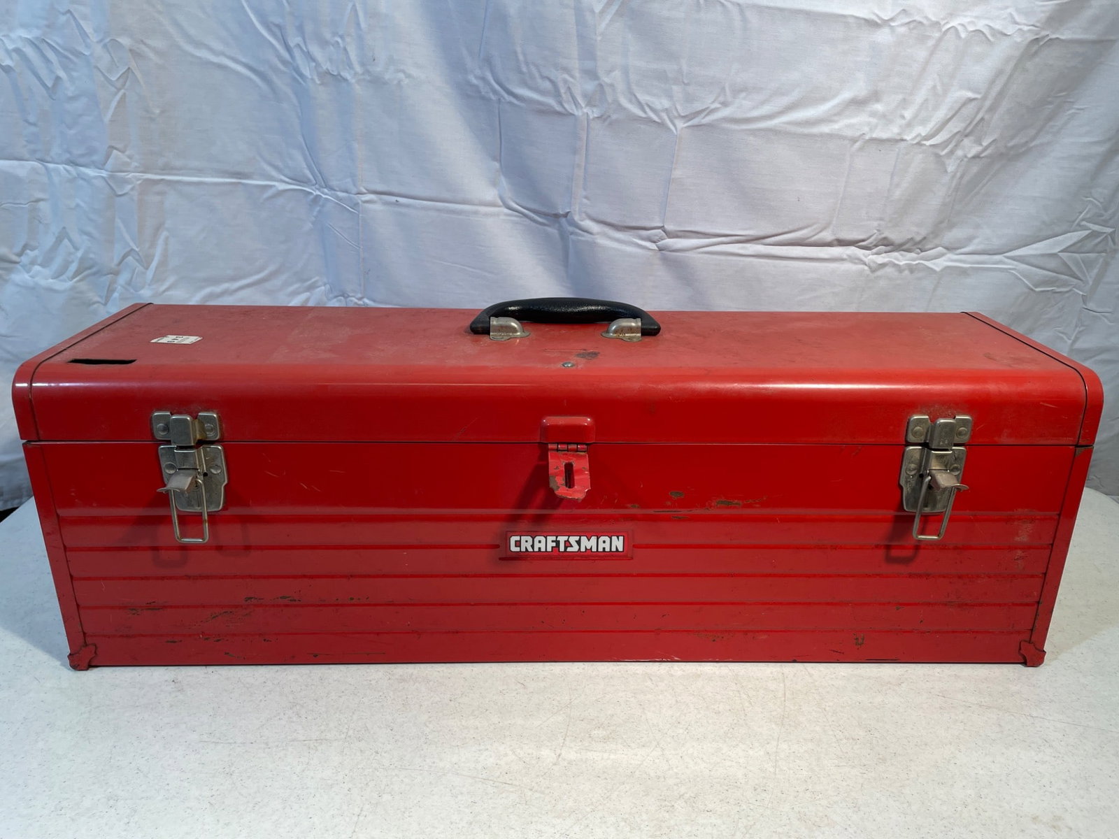 Craftsman Red Metal Toolbox with Assorted Tools: This lot includes a Craftsman red metal toolbox featuring a durable carrying handle and dual latches with a central lock feature. The toolbox contains a variety of hand tools and accessories,