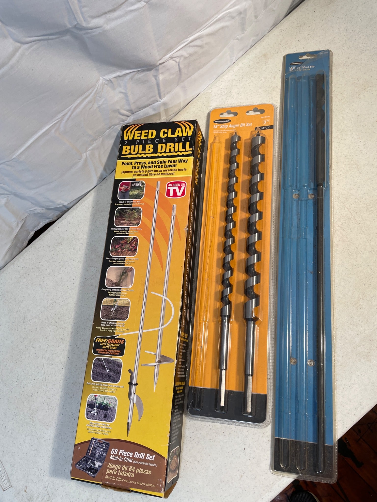 Weed Claw Bulb Drill and Drill Bit Set With Auger Attachments: This lot includes a Weed Claw Bulb Drill set, designed for easy planting and weed removal, and an 18-inch Snap Auger Bit Set, containing 3/4-inch and 1-inch bit sizes. Items are packaged in original