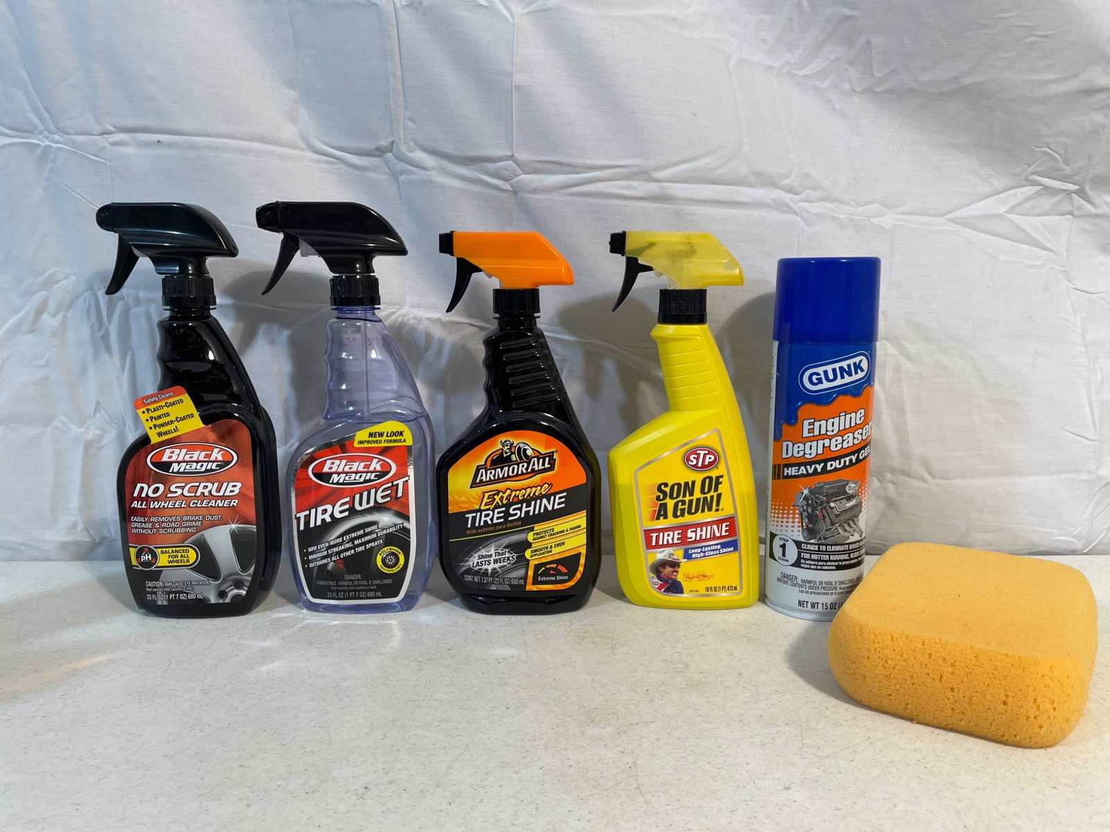 5 Automotive Cleaning and Detailing Products With Sponge: This lot includes five automotive cleaning and detailing products, all at least 75% full or more. Items included are Black Magic No Scrub Wheel Cleaner, Black Magic Tire Wet, Armor All Extreme Tire