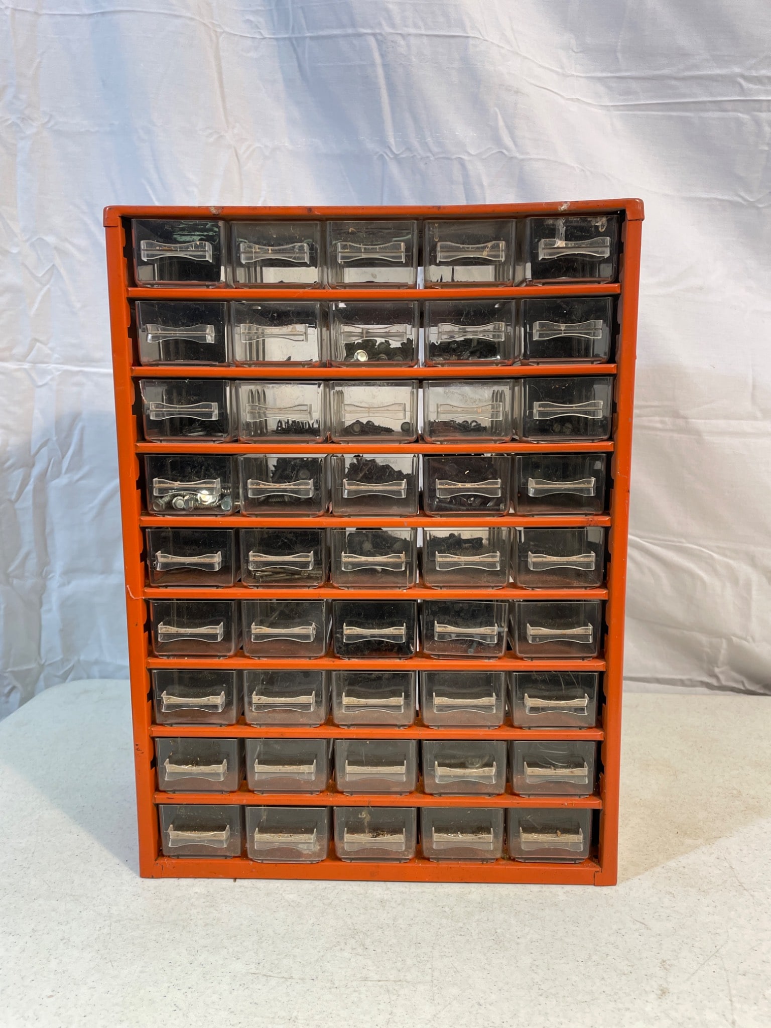 Metal Cabinet With Plastic Drawer Organizers: A metal cabinet featuring multiple plastic drawers for organized storage. Contains 39 compartments, suitable for small parts such as screws or bolts. Dimensions measure approximately 13 inches tall
