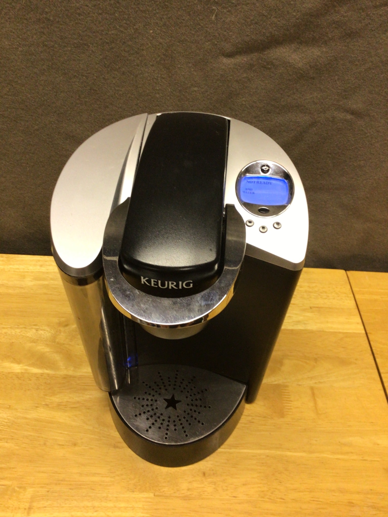 Keurig Single-Serve K-Cup Brewing System: Keurig single-serve coffee maker compatible with K-Cup pods. Features a digital display and removable water reservoir. Model number not specified. The item's exterior is black and silver with a