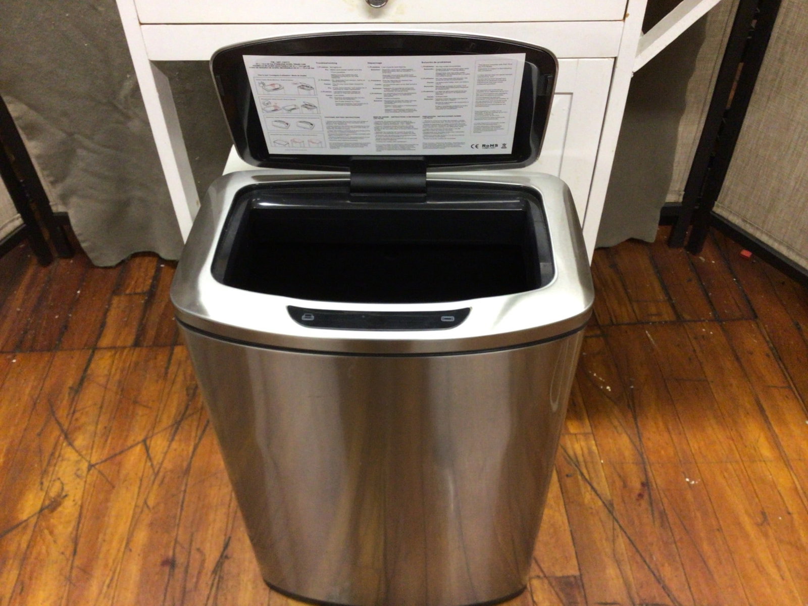 Stainless Steel Touchless Trash Can with Motion Sensor Lid: This is a stainless steel trash can featuring a touchless, motion-sensor-operated lid. The can includes a removable inner bucket for easy cleaning and waste disposal. The underside of the lid shows