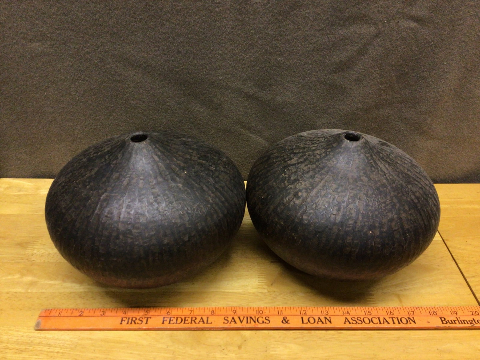 Dark Ceramic Hollow Vessels with Grooved Finish: This lot includes a pair of hollow ceramic vessels, each with a dark finish and a slightly textured grooved surface. Approximate measurements are visible in the images provided, aligning with the