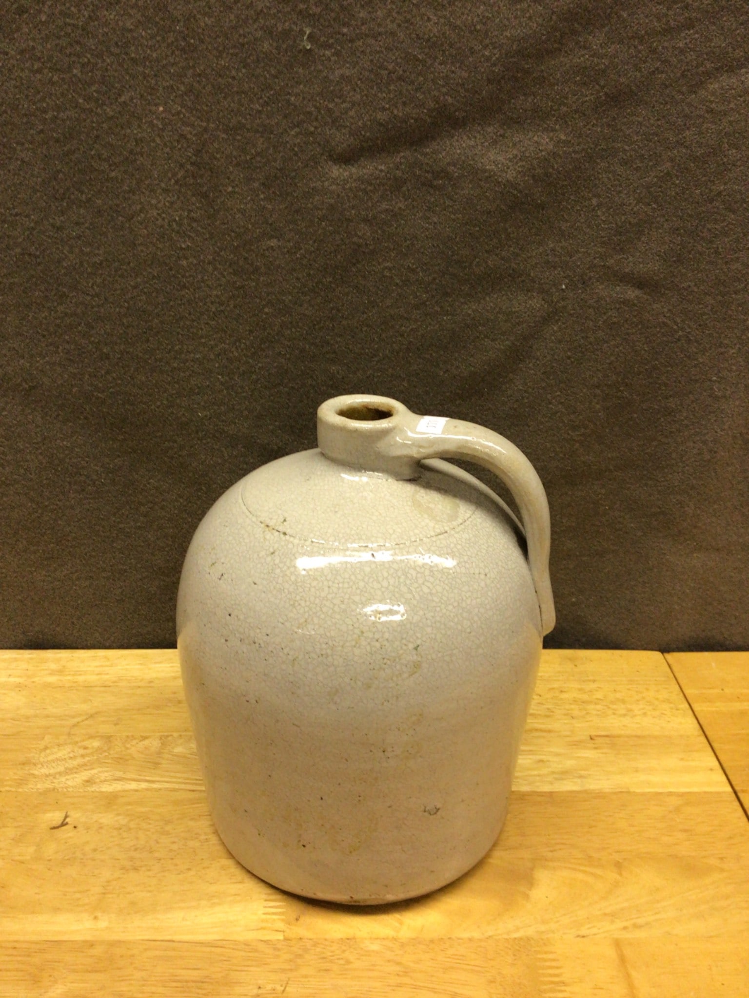Ceramic Jug with Handle and Small Spout: This is a ceramic jug featuring a single handle design and a small spout. The jug is finished in a light glaze, and the exact year of manufacture and maker are unknown. The condition shows minor wear 