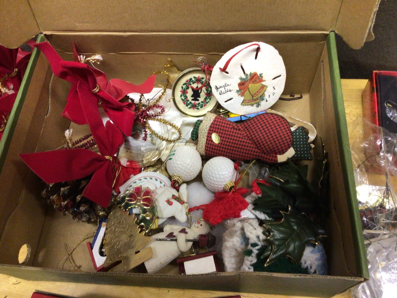 Christmas Ornaments and Accessories: Christmas ornaments, including porcelain and glass ornaments, decorative ribbons, and themed figurines. The lot features items such as a porcelain dove ornament dated 1984, a decorative bell ornament