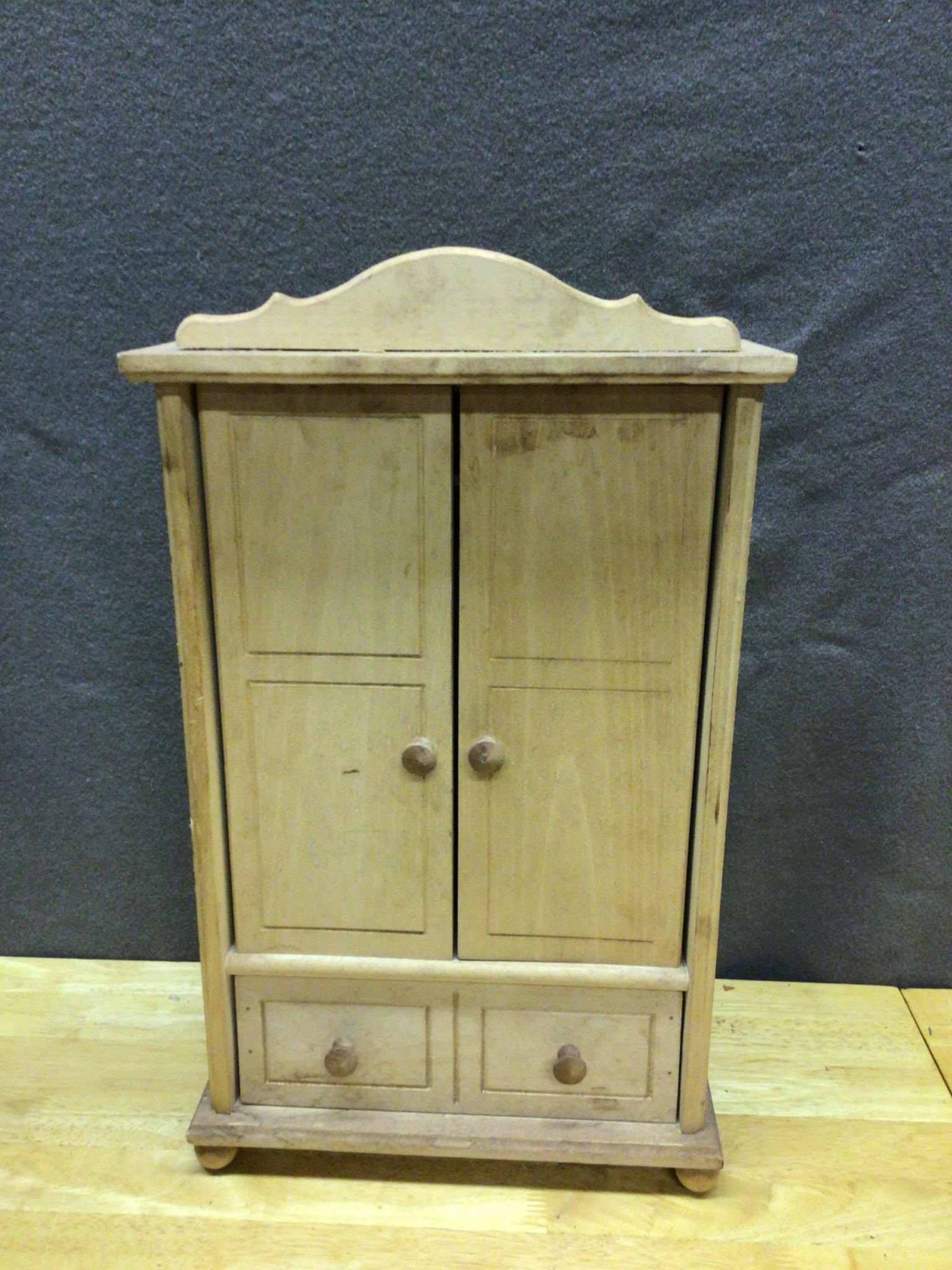 Wooden Miniature Cabinet with Double Doors and Drawers: Wooden miniature cabinet featuring double doors with knob handles, an open interior with a horizontal support rod, and two lower drawers. Includes decorative top trim. Dimensions: approximately 14
