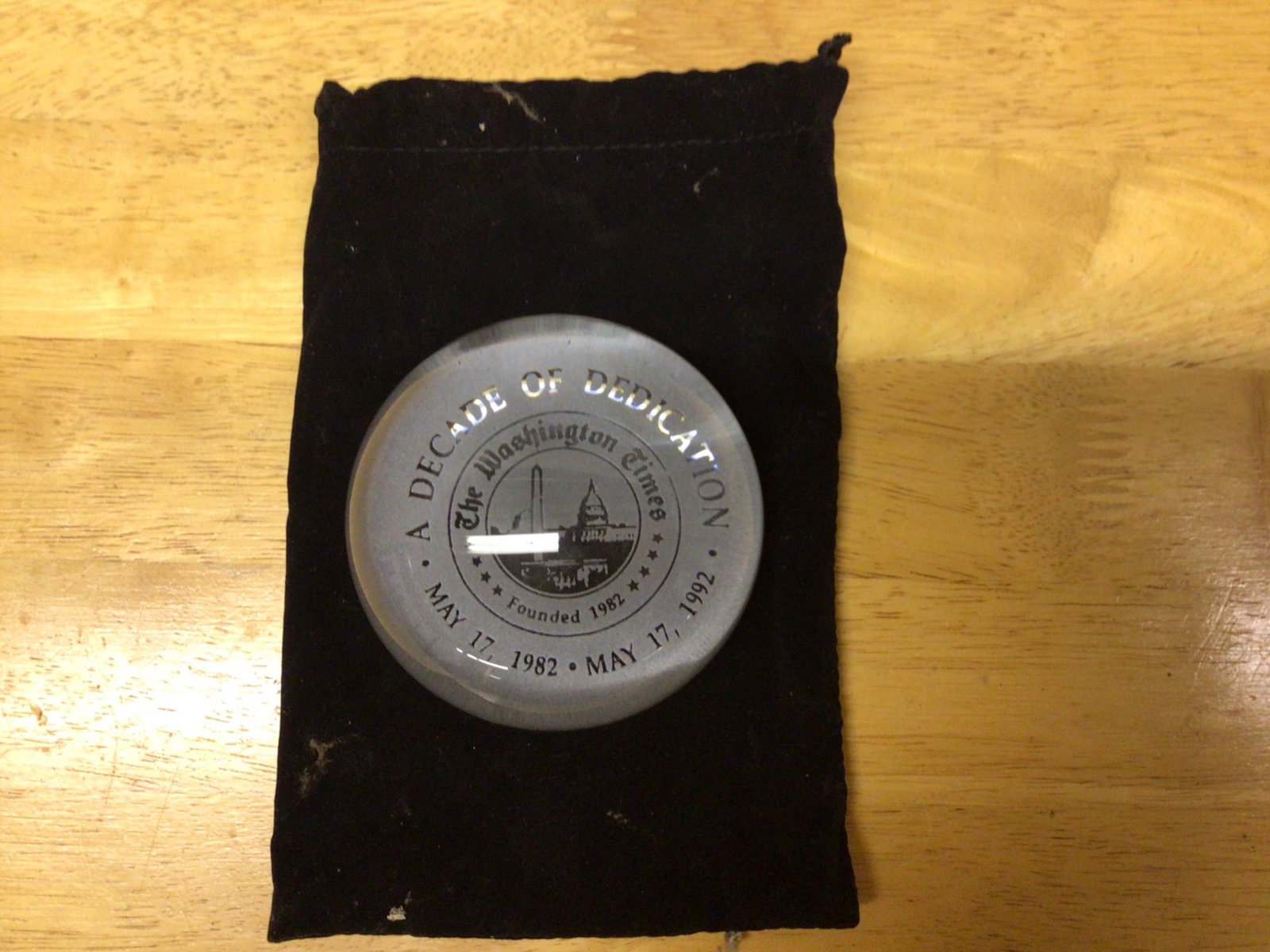 The Washington Times Commemorative Paperweight: A Decade of Dedication (1982-1992): A clear commemorative glass paperweight marking the 10th anniversary of The Washington Times. Engraved with 'A Decade of Dedication' and dates 'May 17, 1982 - May 17, 1992.' Includes original black ve