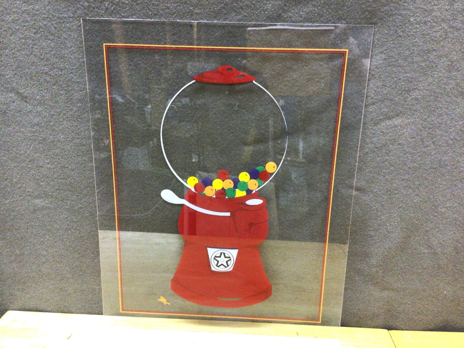 Decorative Artwork Featuring Gumball Machine on Plexiglass: Artwork depicting a gumball machine created on a transparent Plexiglass panel. The design includes multicolored gumballs within a red gumball machine. The panel is lightweight, and there is an orange 