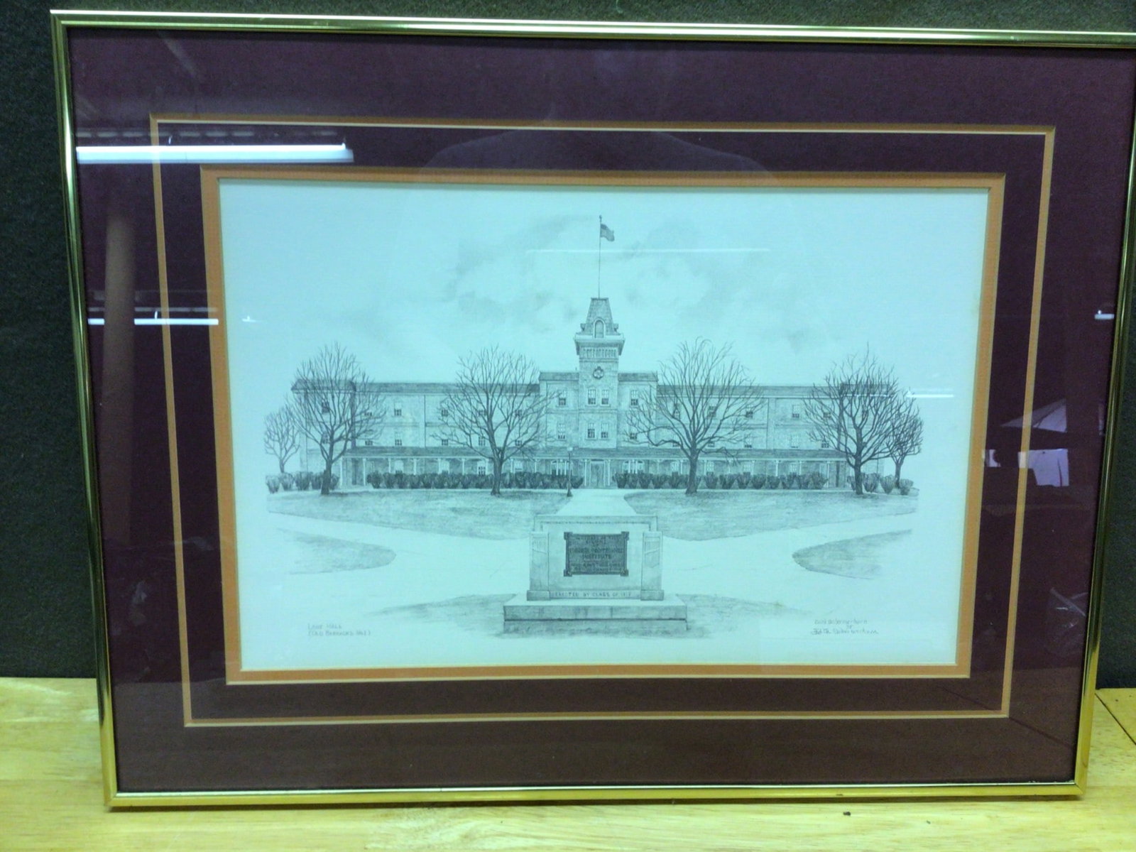 Framed Drawing of Lane Hall (Old Barracks No. 1) by Edith Schlemmer Thorn: Framed drawing depicting Lane Hall, also referred to as Old Barracks No. 1, with a centralized monument. Rendered by Edith Schlemmer Thorn, with signature included in the bottom right corner.