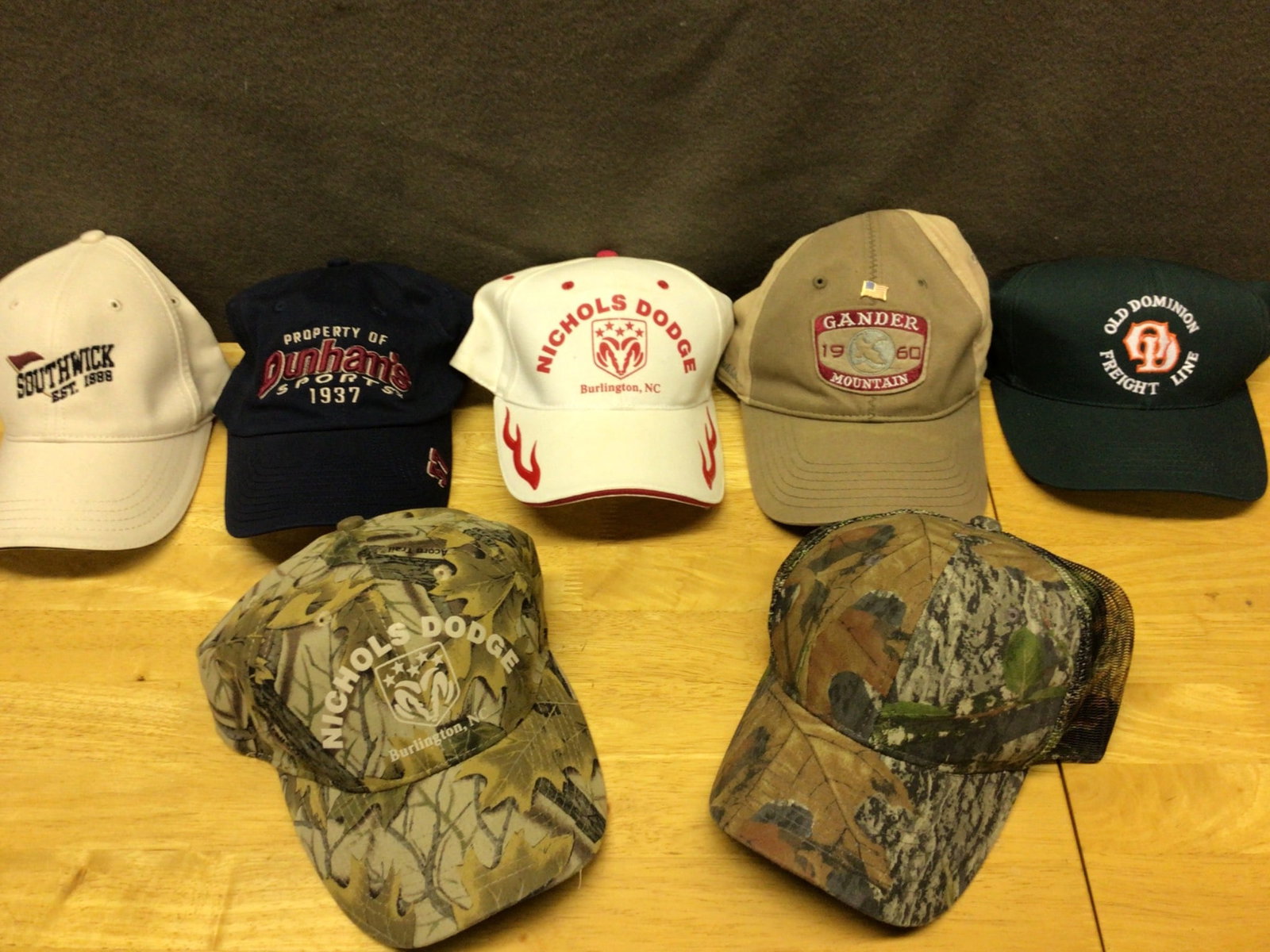 New Hats Featuring Various Brands and Styles: This lot includes six new hats from a collection. Brands and designs include Southwick (Est. 1938), Dunham's Sports (1937), Nichols Dodge (Burlington, NC), Gander Mountain (1960), Old Dominion