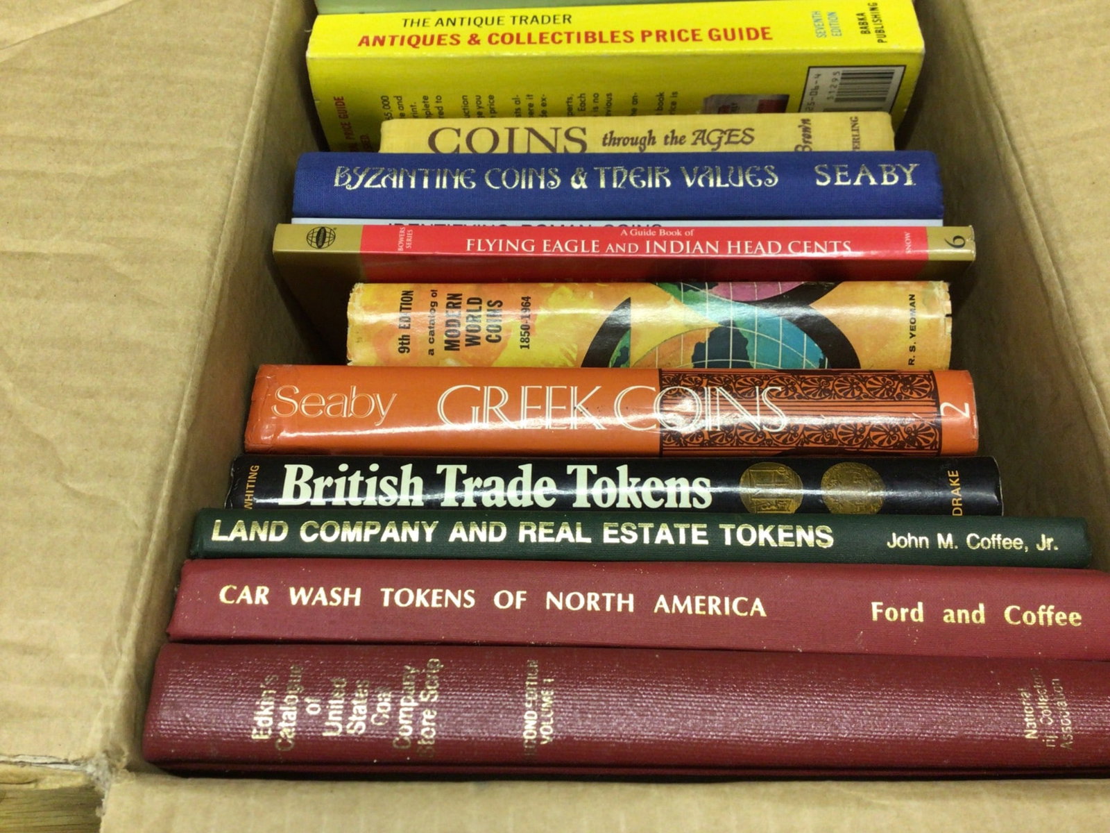 Books on Coins and Tokens, Coin Values, and Identification: This is a collection of books focused on coin collecting, coin values, and identification. Titles include 'The Antique Trader Antiques & Collectibles Price Guide,' 'Coins Through the Ages,' 'Byzantine