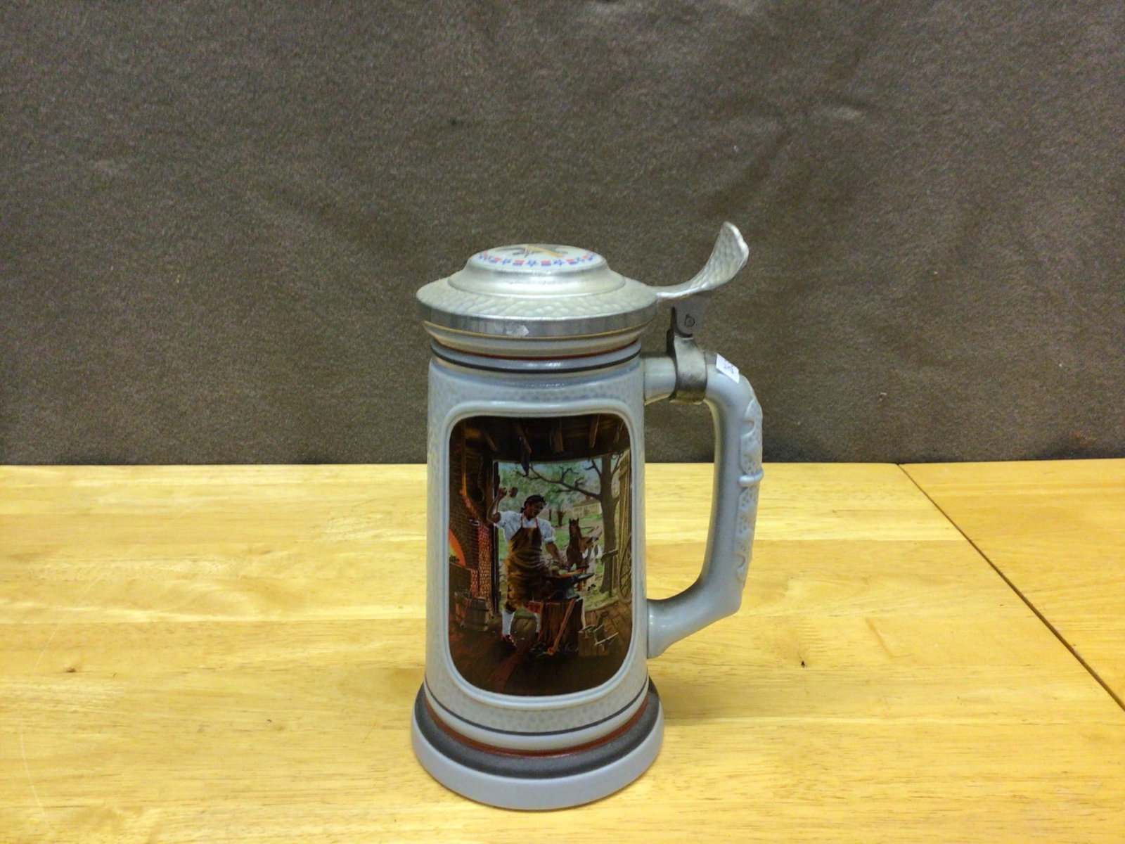 Avon 'The Blacksmith' Stein From The Building of America Collection, 1985: This listing is for an Avon collectible stein titled 'The Blacksmith' from the Building of America collection. Manufactured in 1985 in Brazil, this ceramic and pewter stein features a detailed depicti