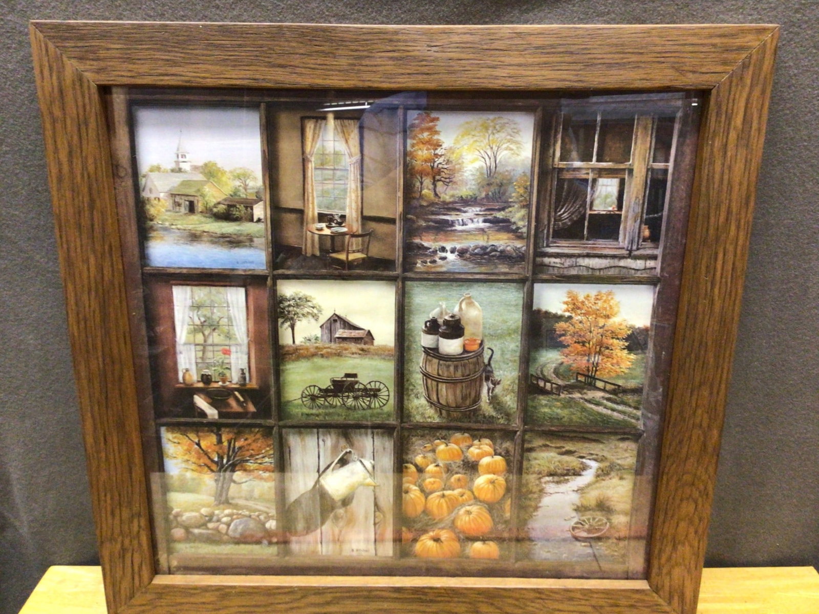 Framed Multi-Panel Artwork Depicting Rural Scenes in Wooden Frame: A multi-panel artwork featuring rural-themed imagery, including barns, pumpkins, a creek, and glass bottles. Each panel showcases different rustic views within a 9-panel grid layout. The artwork