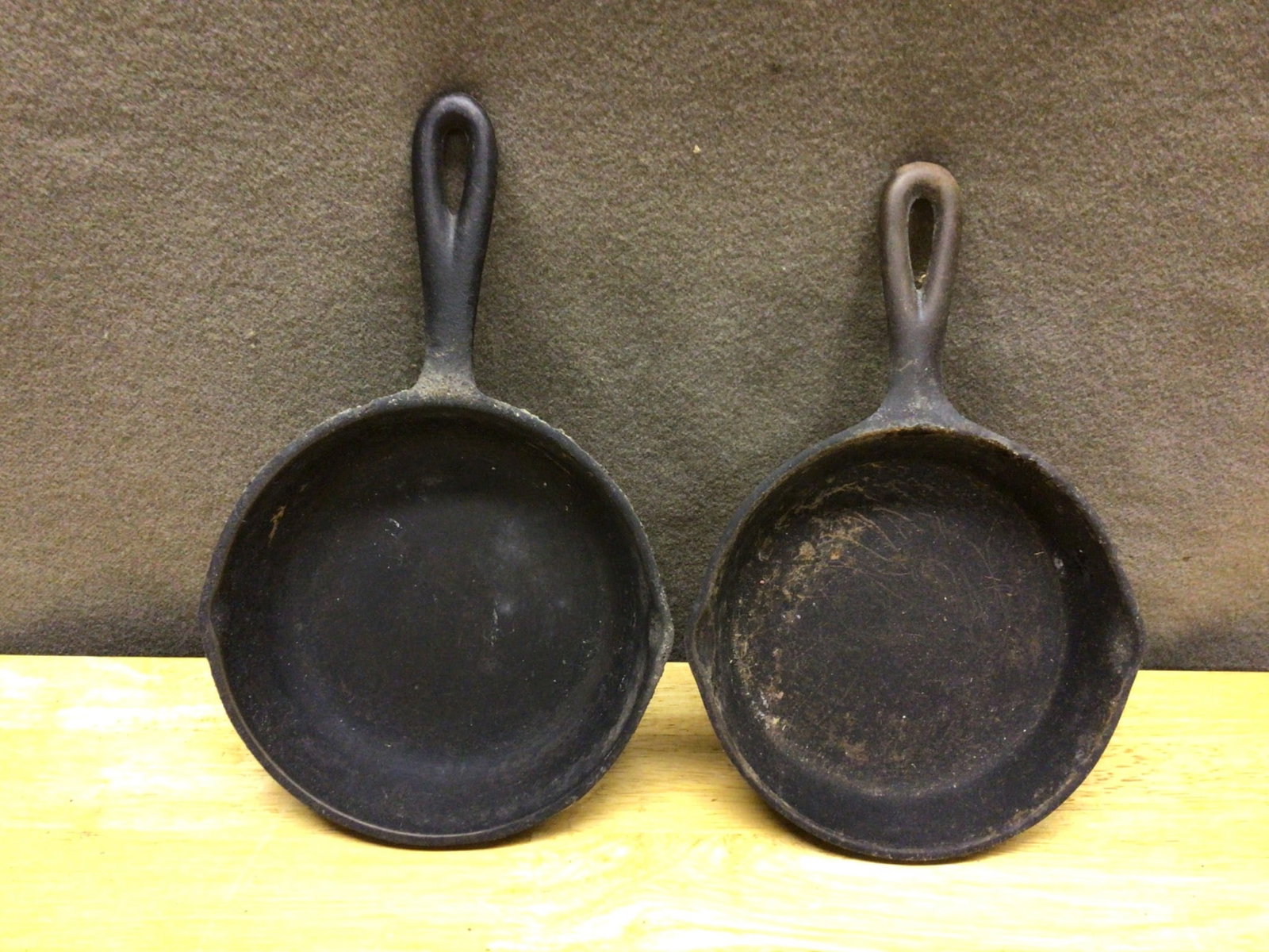 Two Cast Iron Skillets Marked '3' and '3H' with Handles: This lot includes two cast iron skillets. The first skillet is marked with '3H' and the second is marked with '3' on the bottom. Both skillets feature a pour spout on each side and a handle designed