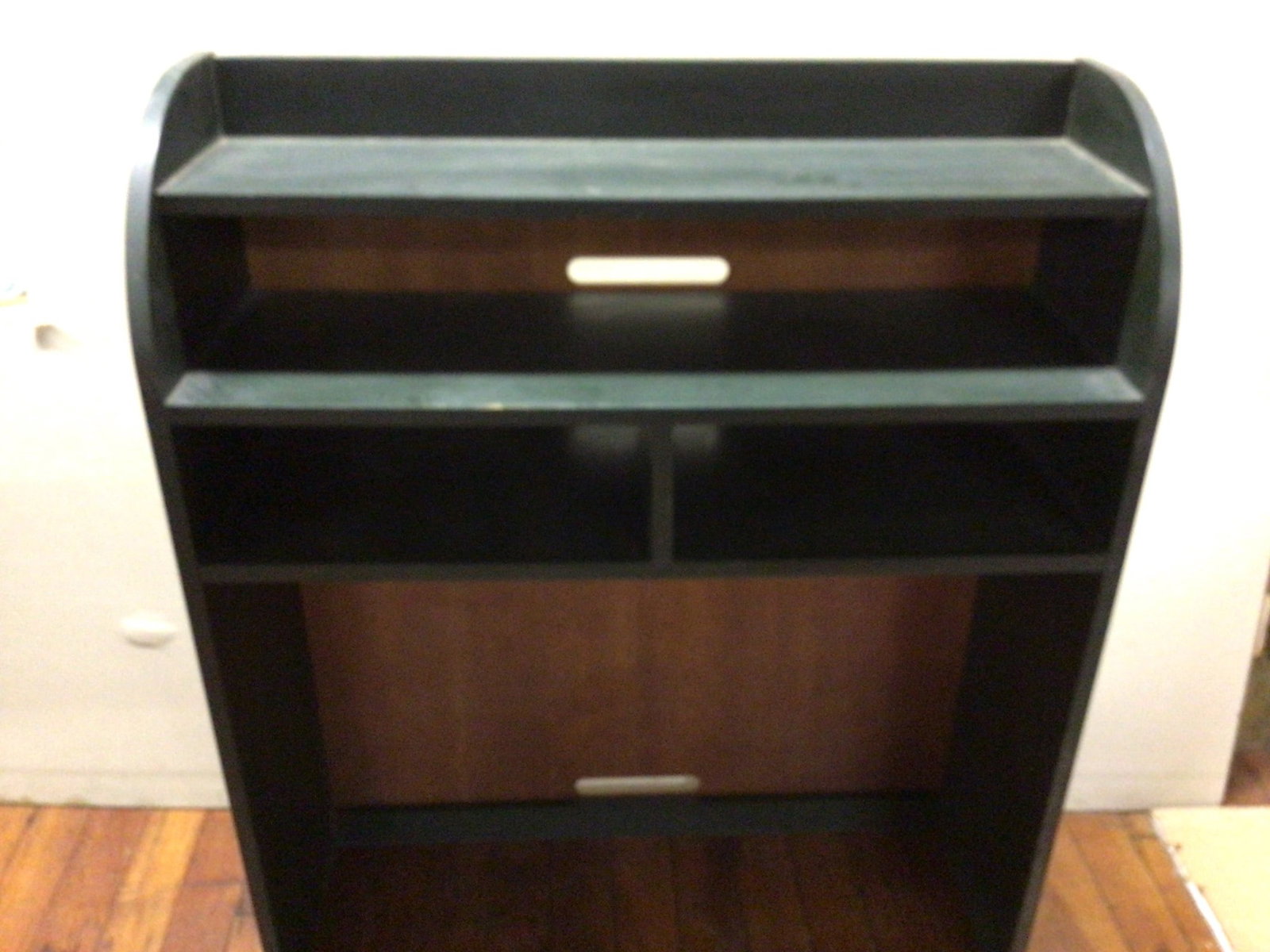 Black Wooden Shelving Unit, 45 Inches Tall, 35 1/2 Inches Wide: Black wooden shelving unit measuring 45 inches tall and 35 1/2 inches wide. Features multiple compartments, including open shelves for storage and organization. The back panel appears to have a