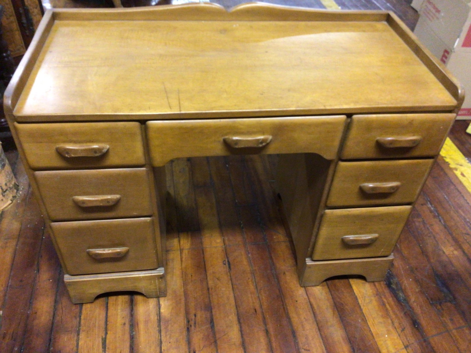 Wooden Desk With Seven Drawers, 42 x 20 Inches: This wooden desk features a total of seven drawers: three on each side and one in the center. The dimensions of the desk are 42 inches in length (left to right) and 20 inches in depth (front to