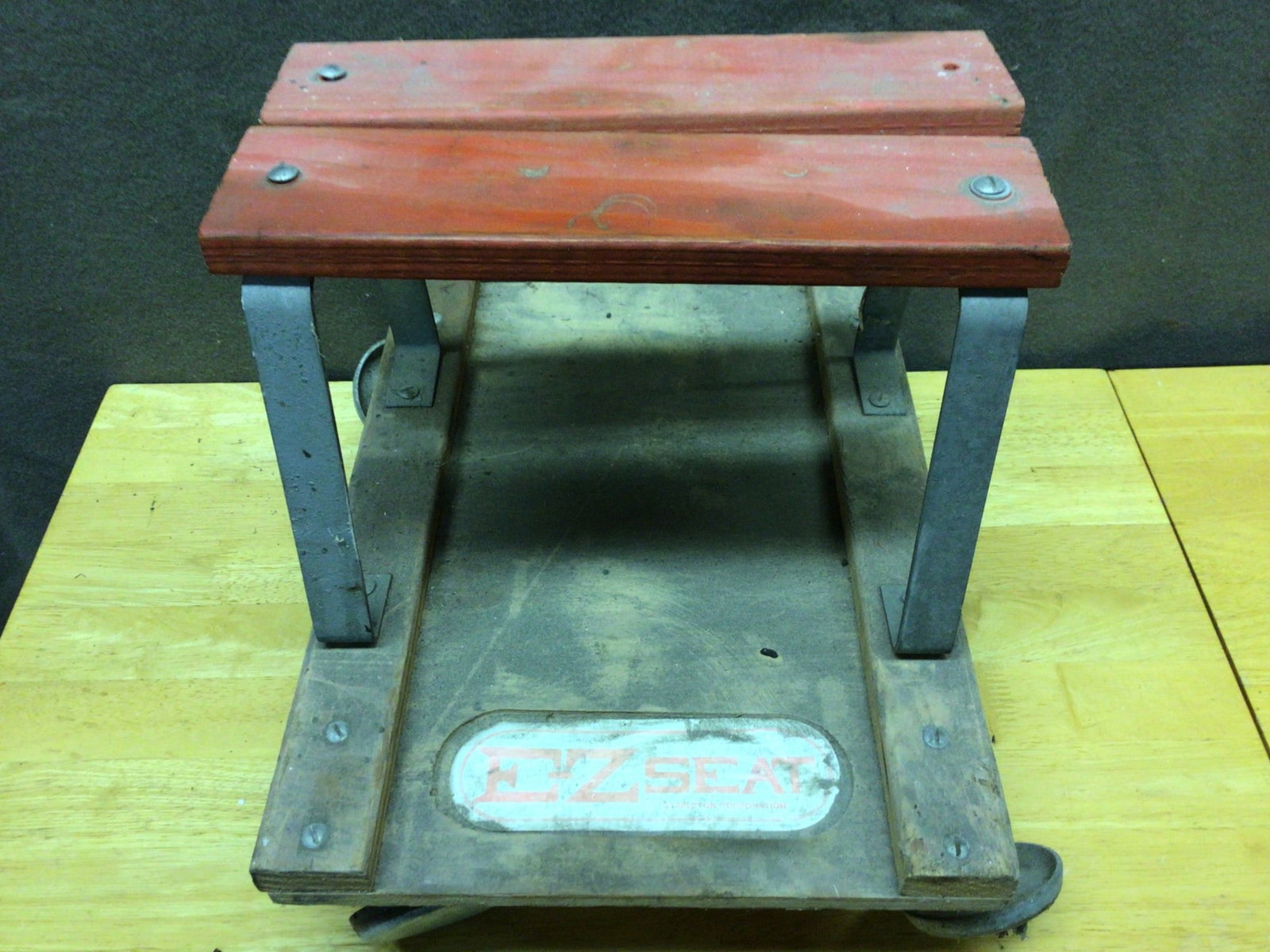 Wood and Metal Wheeled Step Stool Platform with Handle Bracket: A wood and metal wheeled step stool, featuring a wooden top platform and metal support brackets, with rolling wheels underneath. The wooden surface measures approximately 12 inches in length and the