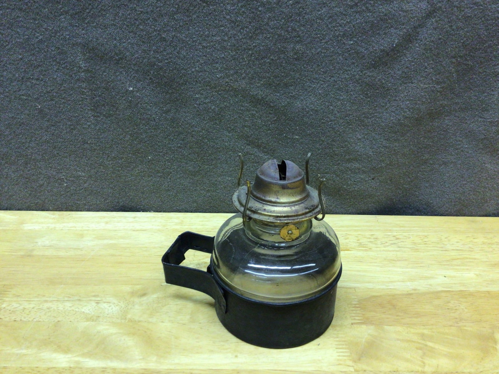 Early 20th Century Glass and Metal Oil Lamp with Handle: This is a glass and metal oil lamp featuring a clear glass reservoir, a metal burner with a wick slot, and a side metal handle. The lamp is designed for manual filling and burning with a removable