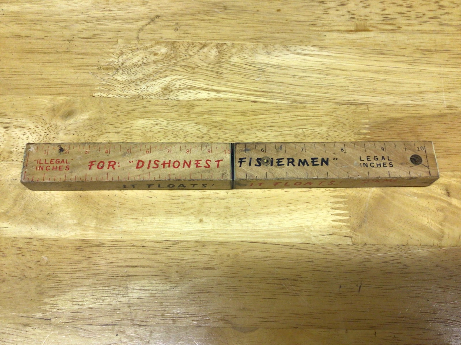 Wooden Fishing Knife with Ruler for Legal and Illegal Length: This item is a dual-purpose fishing knife featuring a stainless steel blade with a serrated edge. The handle doubles as a ruler marked with 'Legal Inches' and 'Illegal Inches' for fishermen. The