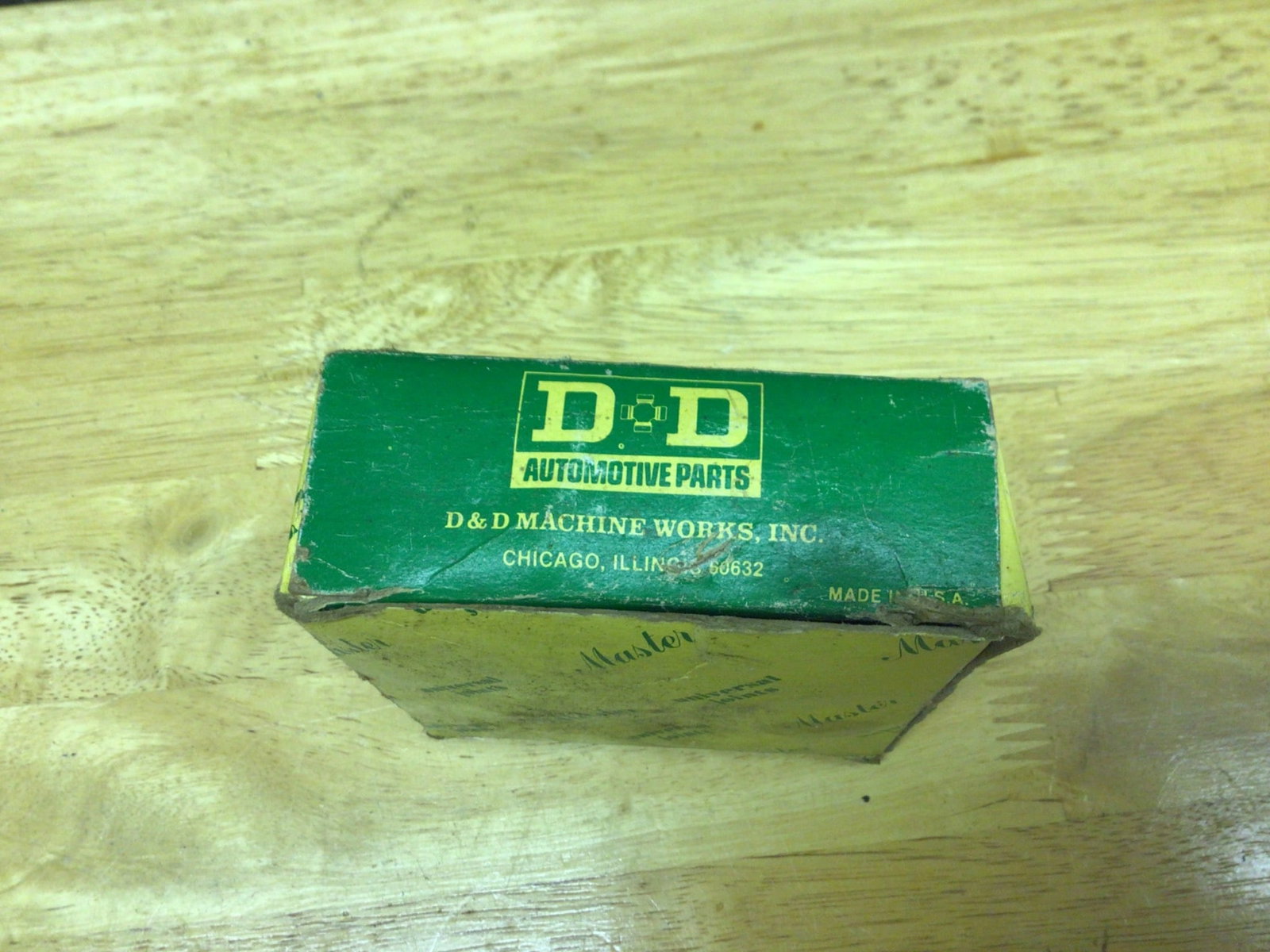 D&D Machine Works Inc. Universal Joint Automotive Part in Original Packaging: This is a D&D Machine Works Inc. universal joint automotive part. It is made in the USA as indicated on the part itself. The item is unused and still in its original packaging, which shows storage wea