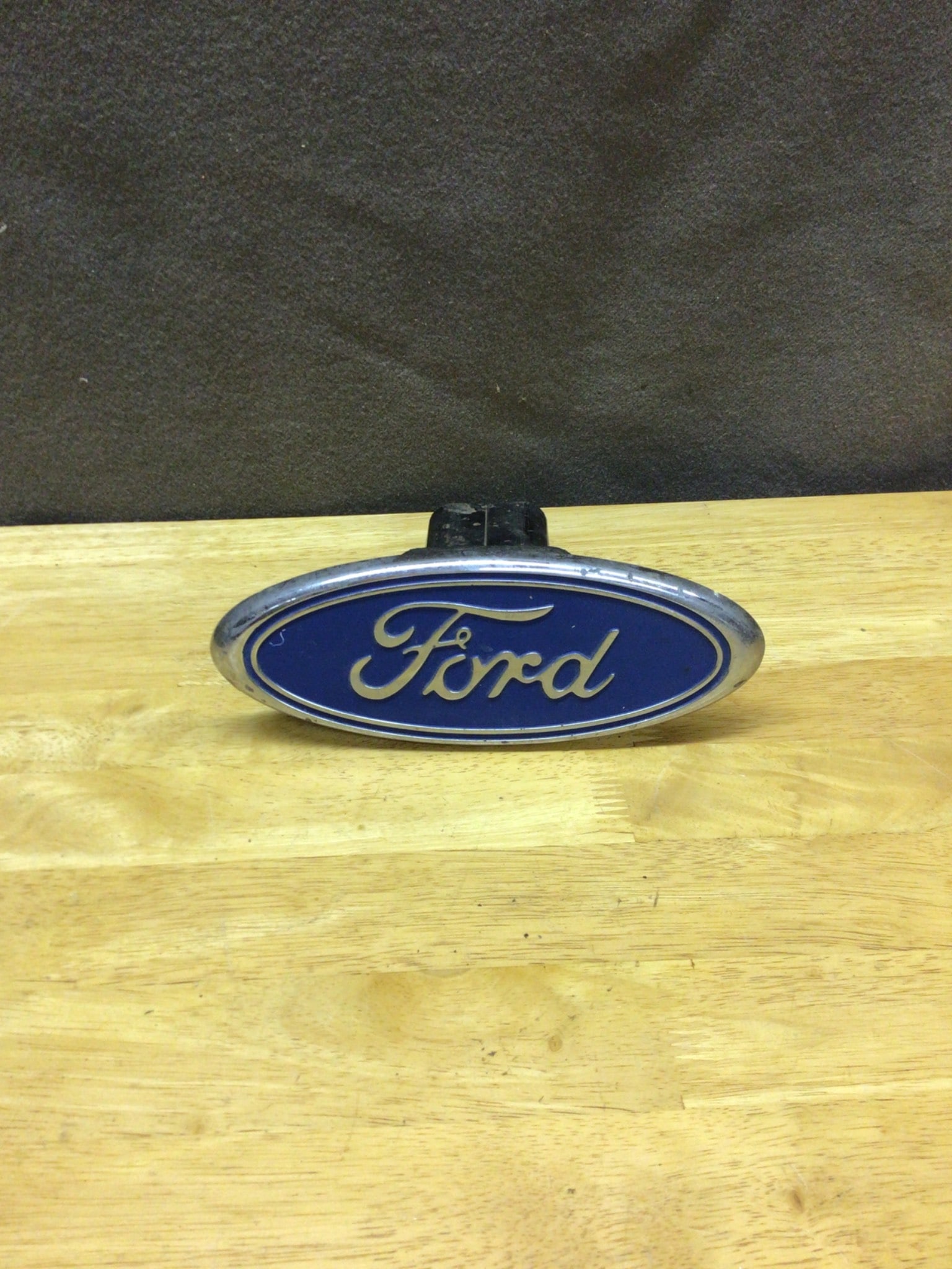 Ford Oval Hitch Cover Emblem With Mounting Piece: Ford oval emblem designed to serve as a hitch cover. Features blue enamel with silver-toned trim and logo script. Made of metal with a mounting piece affixed to the base. Dimensions approximately 6