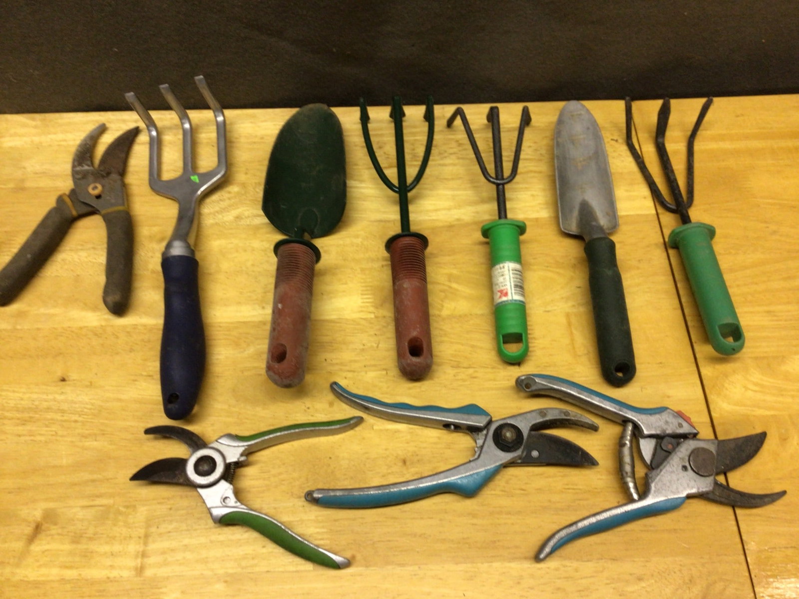 10 Garden Hand Tools Including Pruners, Trowels, and Hand Forks: 10 garden hand tools including pruners, trowels, and hand forks. The assortment includes tools with ergonomic and basic plastic or rubber grips, featuring both single-piece and multi-piece designs.