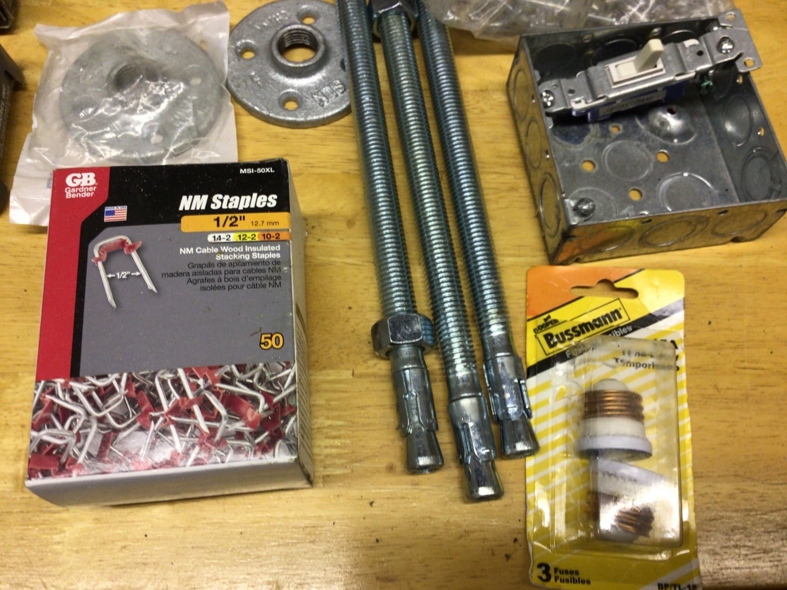 Hardware Lot Featuring Screws, Staples, Fasteners, and Electrical Components: This lot contains a variety of hardware, including a box containing several hundred small screws, Grip-Rite fasteners, GB NM staples (1/2 inch, pack of 50), a Craftsman tool attachment, galvanized