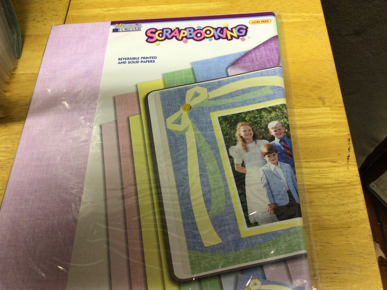 Scrapbooking Supplies and Construction Paper Set: This lot features an assortment of scrapbooking materials, including reversible patterned and solid paper sheets, decorative frames, stickers, and other thematic accessories. Items are organized in a