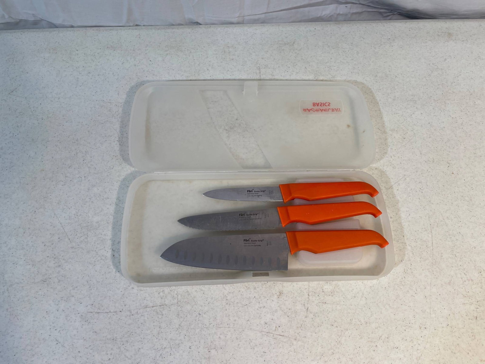 3 Furi Coppertail Pro Stainless Steel Knives with Case: Three Furi knives featuring stainless steel blades and orange Coppertail handles. Includes 2 Santoku knives and 1 utility knife, housed in a plastic storage case. Markings on the blades include the