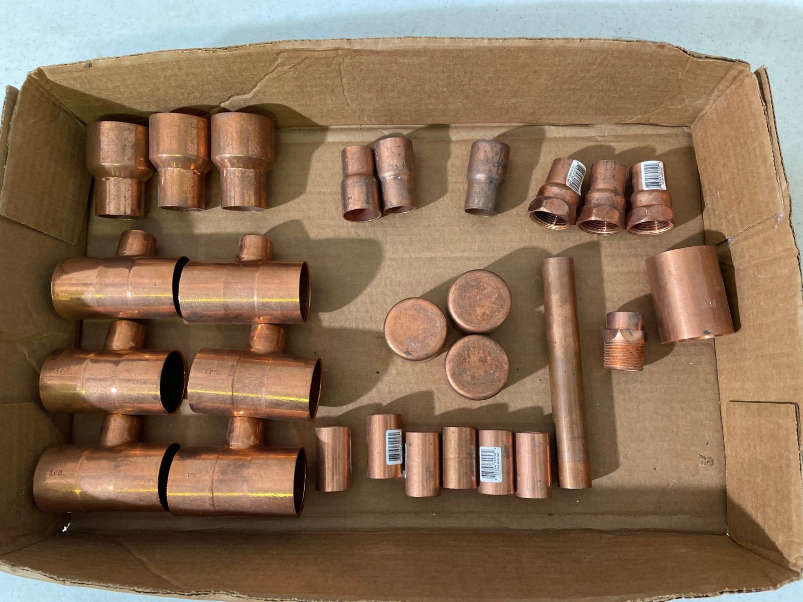 Copper Pipe Fittings and Connectors: This lot includes assorted copper pipe fittings and connectors such as tees, caps, reducers, and nipples. The fittings appear to be of varying sizes suitable for plumbing or HVAC applications. Some
