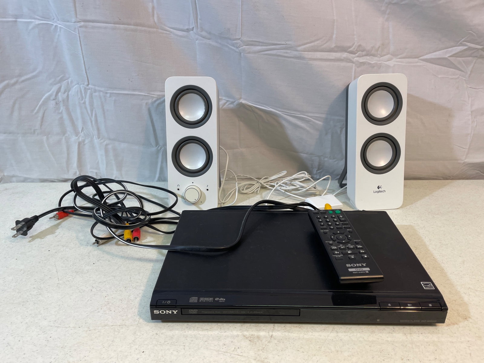 Sony DVD Player DVP-SR210P with Remote and Logitech Speakers: Sony DVD Player model DVP-SR210P, includes the Sony remote control (model RMT-D187A) and a set of Logitech external speakers. The unit has been tested and is confirmed to be in working condition.