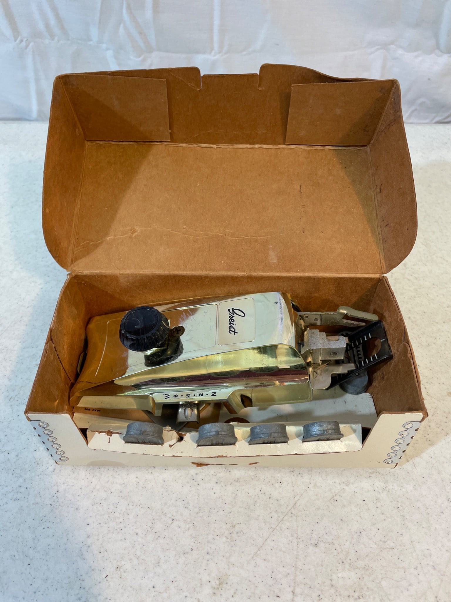 Greist The Buttonholer Sewing Machine Attachment with Original Box: This is a Greist 'The Buttonholer' sewing machine attachment in its original packaging. Includes keyhole designs and capability for making buttonholes automatically. The exact make/model year is